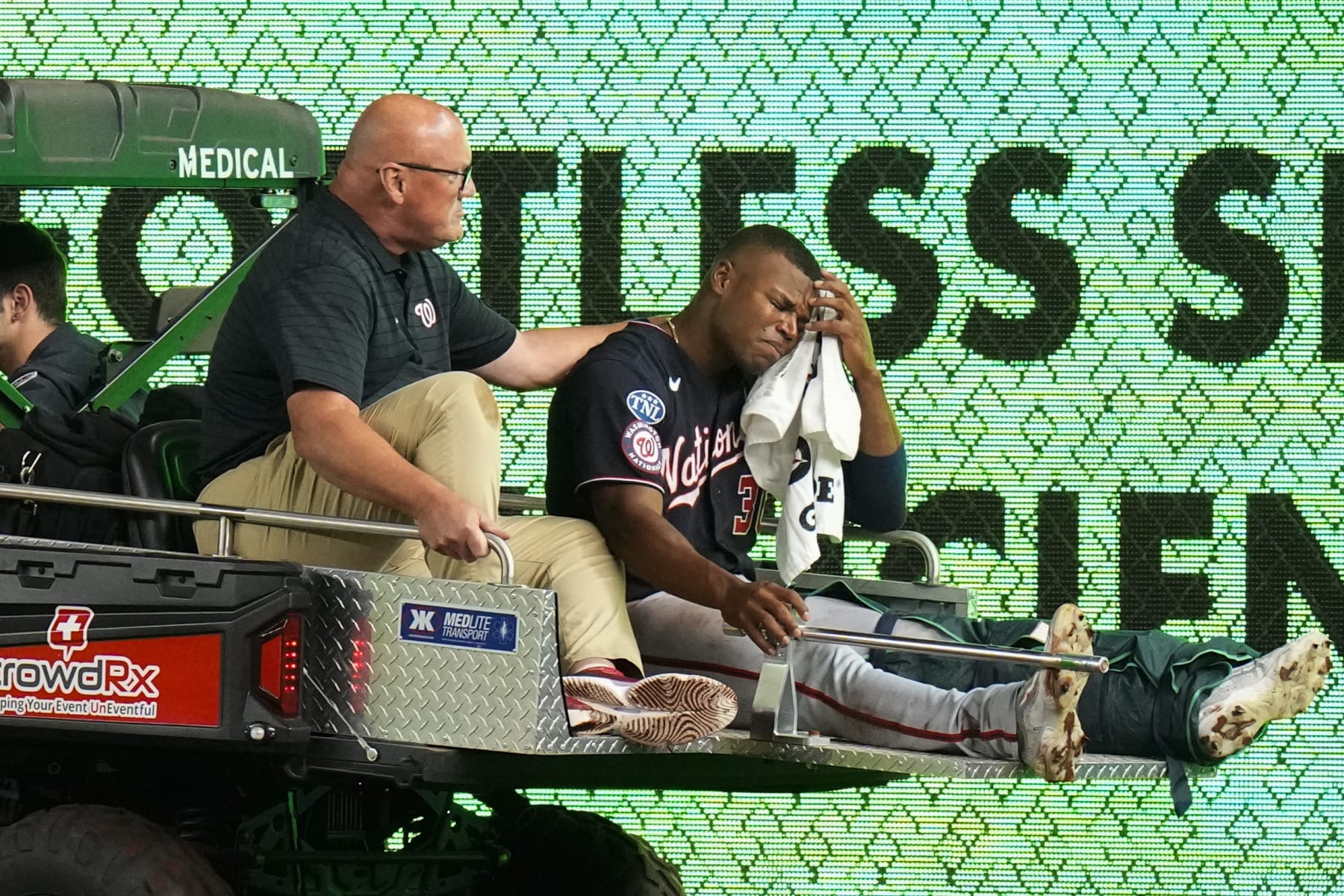 A trainer comforts Washington Nationals left fielder Stone Garrett, who is carted off the field after being injured during the seventh inning of the team's baseball game against the New York Yankees on Wednesday, Aug. 23, 2023, in New York. (AP Photo/Frank Franklin II)