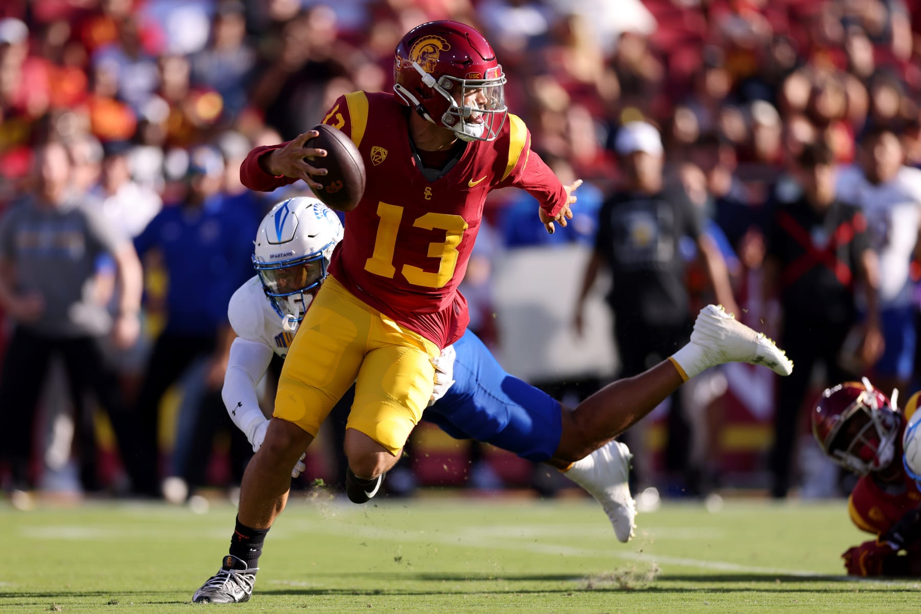 LOS ANGELES, CALIFORNIA - AUGUST 26: Caleb Williams #13 of the USC Trojans avoids the tackle against Elijah Wood #14 of the San Jose State Spartans during the second quarter at United Airlines Field at the Los Angeles Memorial Coliseum on August 26, 2023 in Los Angeles, California. (Photo by Katelyn Mulcahy/Getty Images)