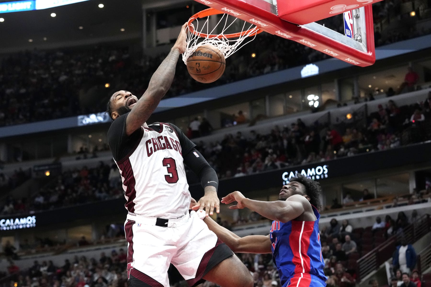 Chicago Bulls center Andre Drummond, left, dunks as Detroit Pistons center James Wiseman looks on during the second half of an NBA basketball game in Chicago, Sunday, April 9, 2023. The Bulls won 103-81. (AP Photo/Nam Y. Huh)