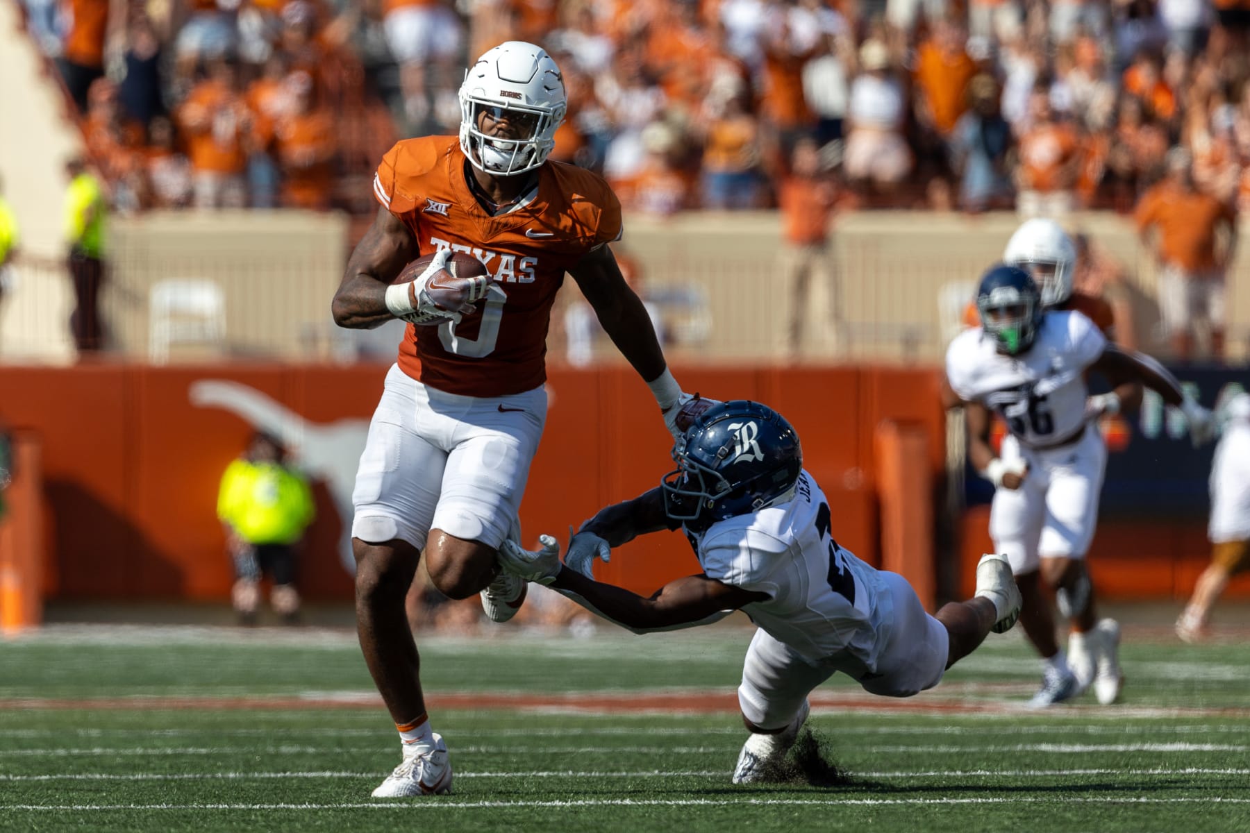 AUSTIN, TX - SEPTEMBER 02: Texas Longhorns tight end Ja'Tavion Sanders (0) stiff arms Rice Owls cornerback Jonathan Jean (22) after a catch and runs in for a touchdown during the college football game between Texas Longhorns and Rice Owls on September 2, 2023, at Darrell K Royal-Texas Memorial Stadium in Austin, TX.  (Photo by David Buono/Icon Sportswire via Getty Images)
