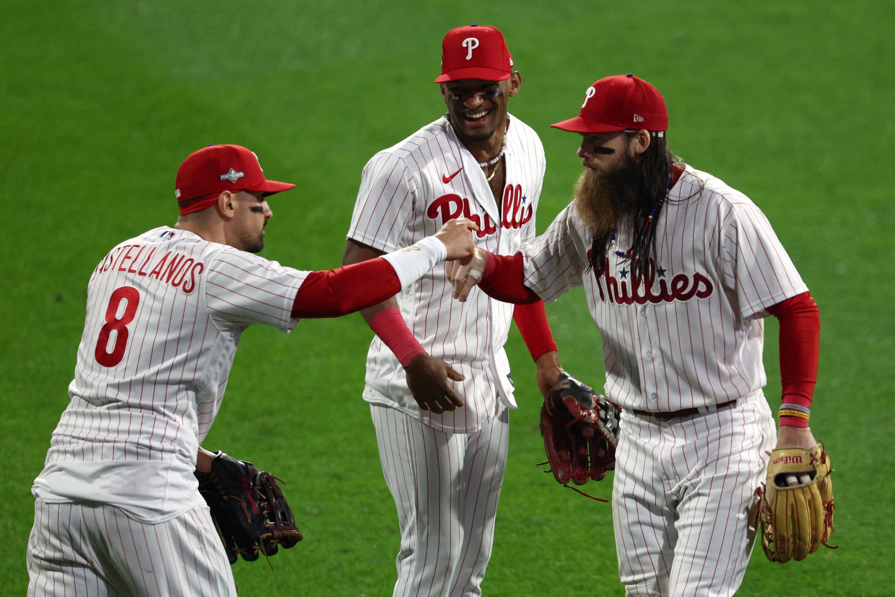 PHILADELPHIA, PENNSYLVANIA - OCTOBER 17: Nick Castellanos #8, Brandon Marsh #16 and Johan Rojas #18 of the Philadelphia Phillies celebrate a 10-0 win over the Arizona Diamondbacks during Game Two of the Championship Series at Citizens Bank Park on October 17, 2023 in Philadelphia, Pennsylvania. (Photo by Elsa/Getty Images)