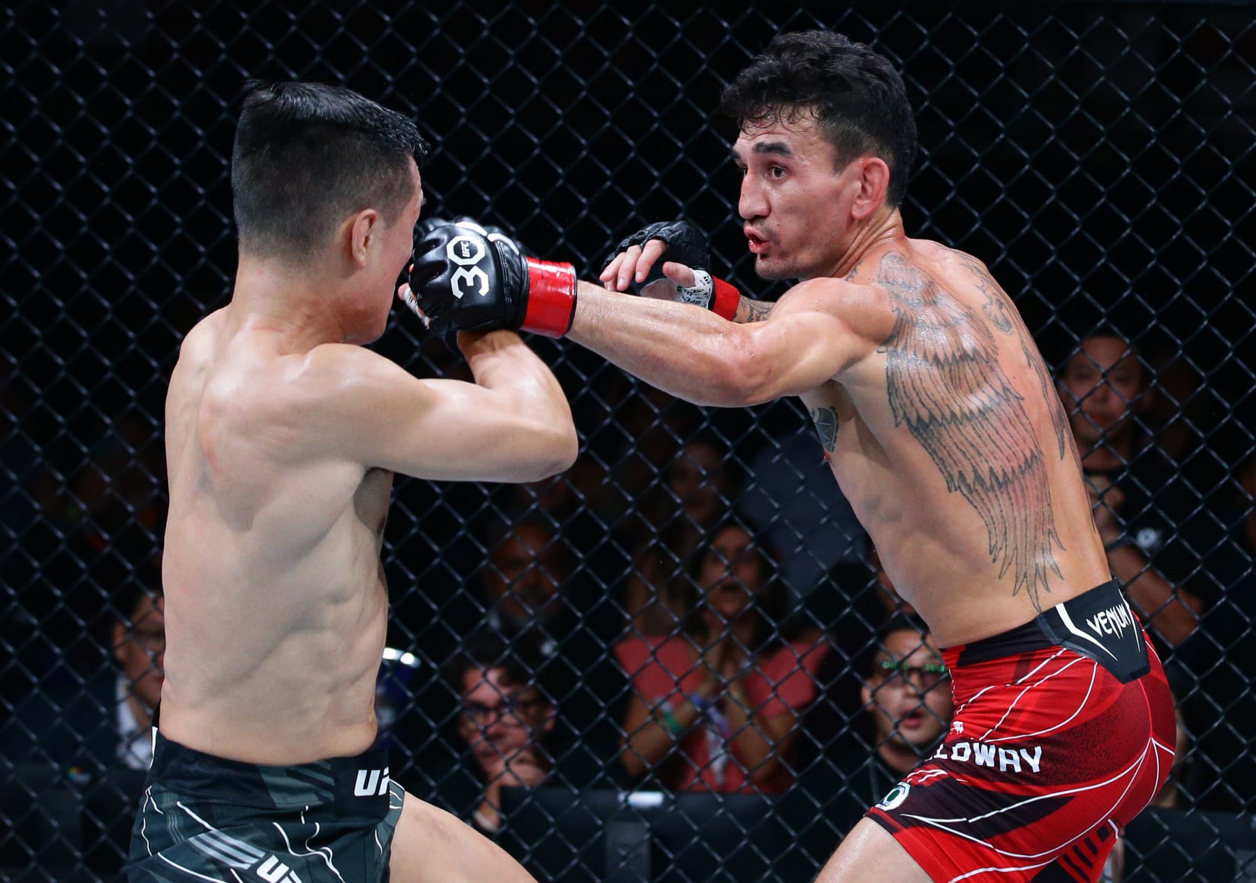 SINGAPORE, SINGAPORE - AUGUST 26: (R-L) Max Holloway punches Chan Sung Jung of South Korea in a featherweight bout during the UFC Fight Night event at Singapore Indoor Stadium on August 26, 2023 in Singapore. (Photo by Suhaimi Abdullah/Zuffa LLC via Getty Images)
