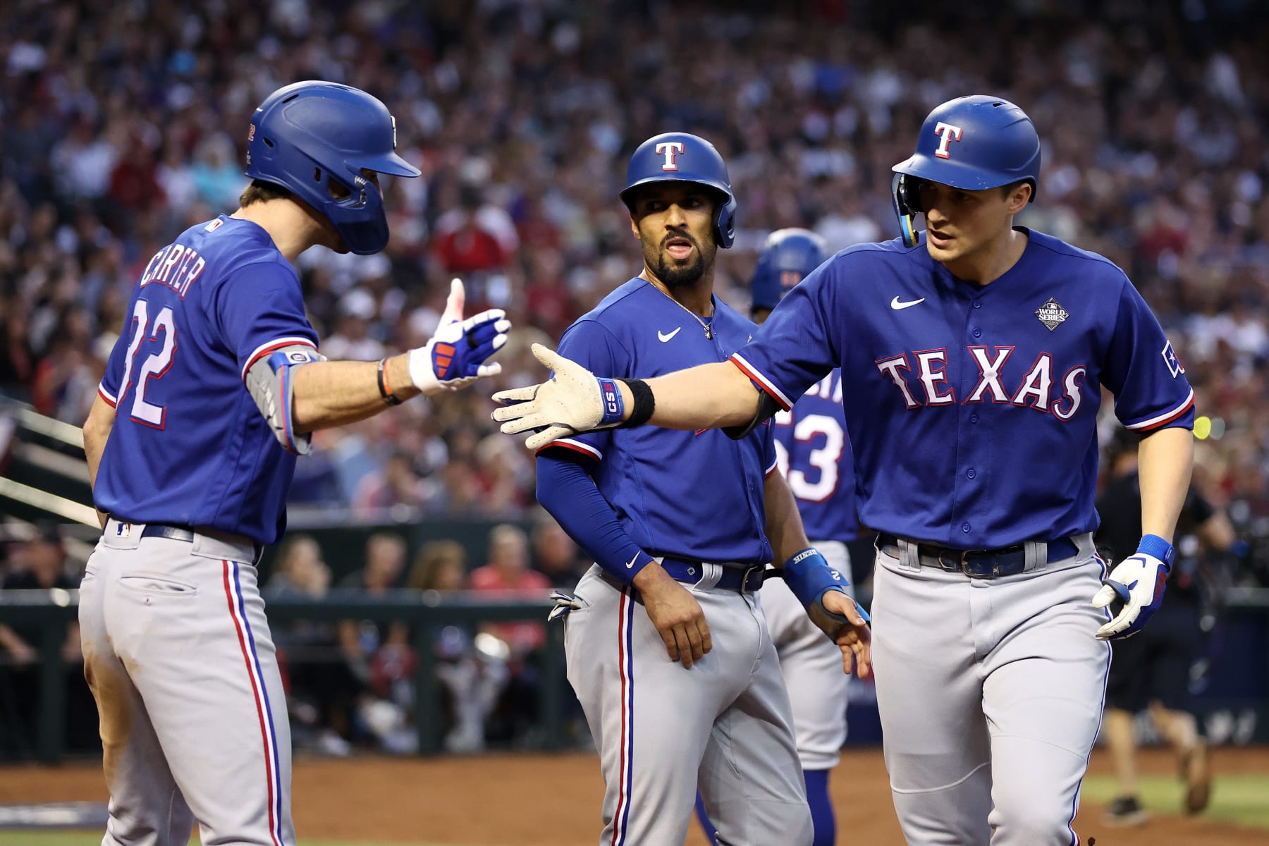 PHOENIX, ARIZONA - OCTOBER 30: Evan Carter #32 and Corey Seager #5 of the Texas Rangers celebrate after Seager hit a home run in the third inning against the Arizona Diamondbacks during Game Three of the World Series at Chase Field on October 30, 2023 in Phoenix, Arizona. (Photo by Christian Petersen/Getty Images)