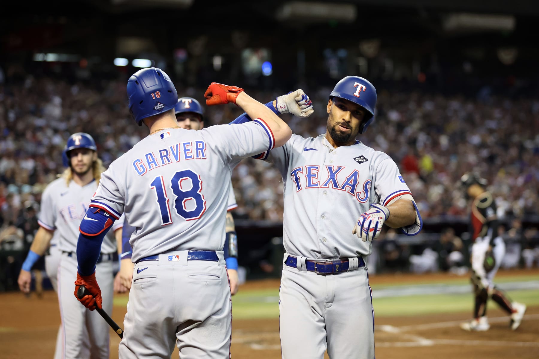 PHOENIX, ARIZONA - OCTOBER 31: Mitch Garver #18 and Marcus Semien #2 of the Texas Rangers celebrate after Semien hit a home run in the third inning against the Arizona Diamondbacks during Game Four of the World Series at Chase Field on October 31, 2023 in Phoenix, Arizona. (Photo by Christian Petersen/Getty Images)