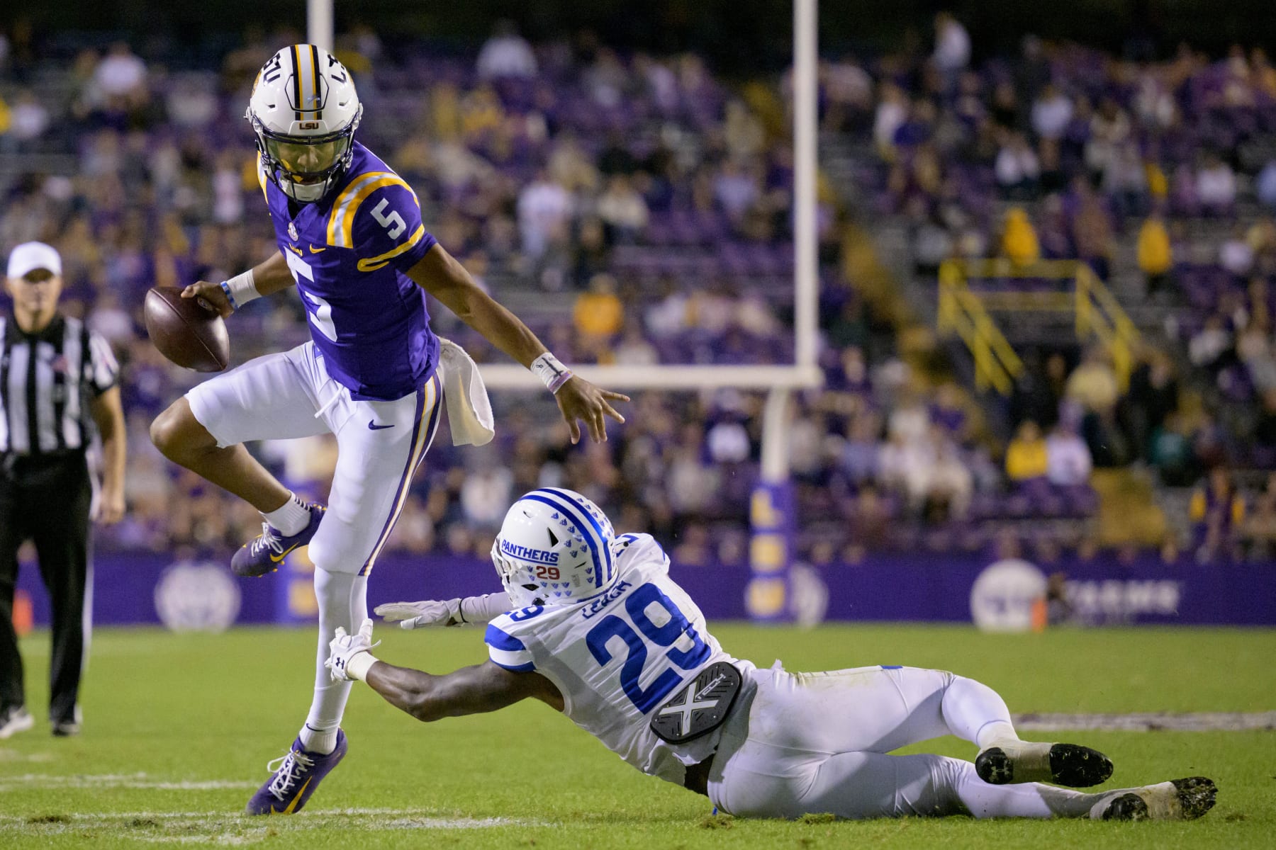 LSU quarterback Jayden Daniels (5) runs against Georgia State safety TyGee Leach (29) during the second half of an NCAA college football game in Baton Rouge, La., Saturday, Nov. 18, 2023. (AP Photo/Matthew Hinton)