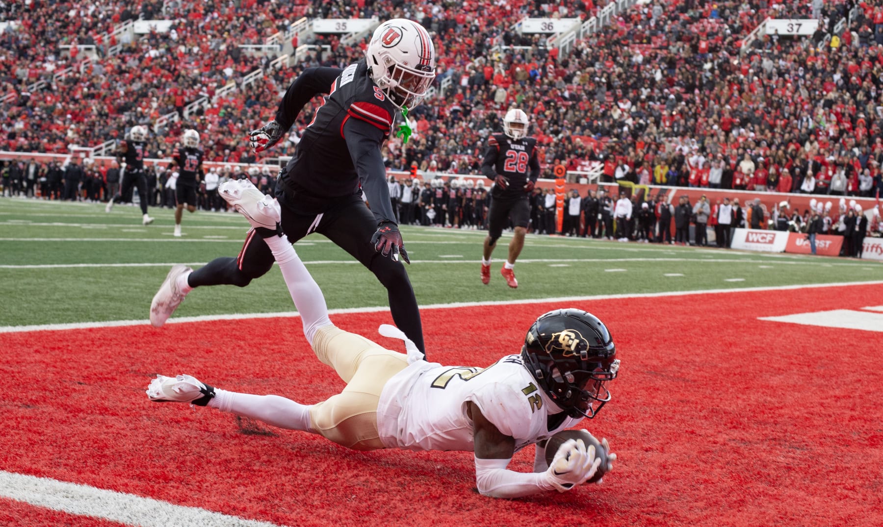 SALT LAKE CITY, UT - NOVEMBER 25:  Hunter Travis #12 of the Colorado Buffaloes can't hold on to a pass in the endzone as he is covered by Zemaiah Vaughn #5 of the Utah Utes during the first half of their game at Rice Eccles Stadium on November 25, 2023 in Salt Lake City, Utah.  (Photo by Chris Gardner/Getty Images)