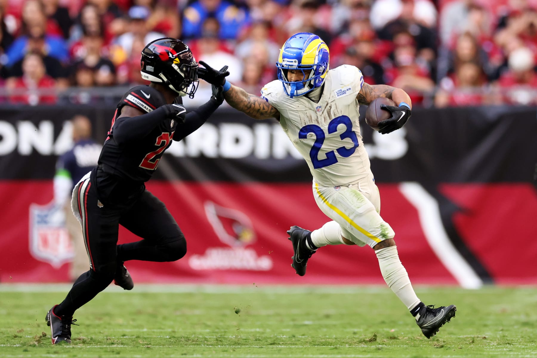 GLENDALE, ARIZONA - NOVEMBER 26: Kyren Williams #23 of the Los Angeles Rams stiff arms Divaad Wilson #27 of the Arizona Cardinals during the second quarter at State Farm Stadium on November 26, 2023 in Glendale, Arizona. (Photo by Christian Petersen/Getty Images)