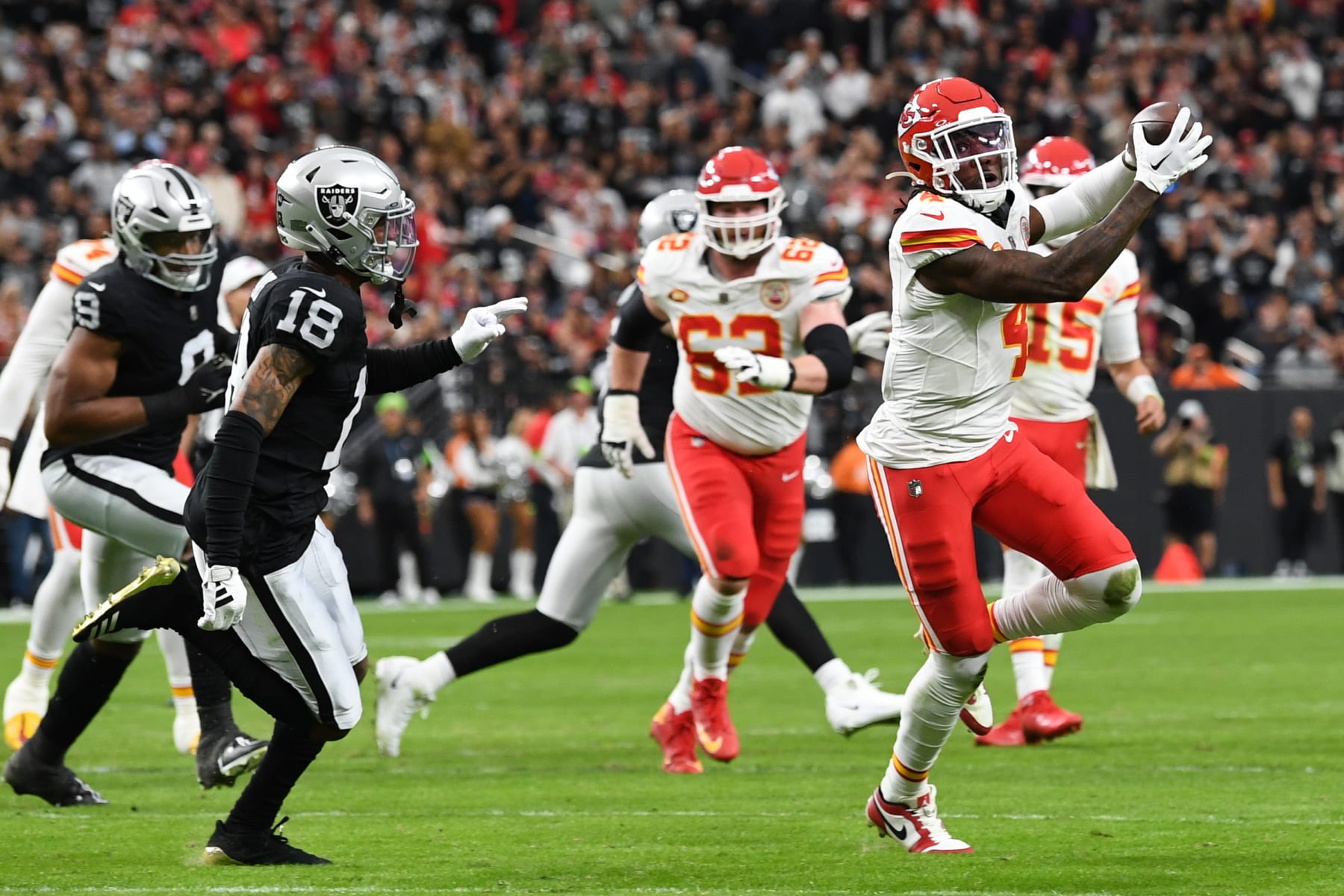 LAS VEGAS, NEVADA - NOVEMBER 26: Rashee Rice #4 of the Kansas City Chiefs catches a pass in front of Jack Jones #18 of the Las Vegas Raiders during the second quarter at Allegiant Stadium on November 26, 2023 in Las Vegas, Nevada. (Photo by Candice Ward/Getty Images)