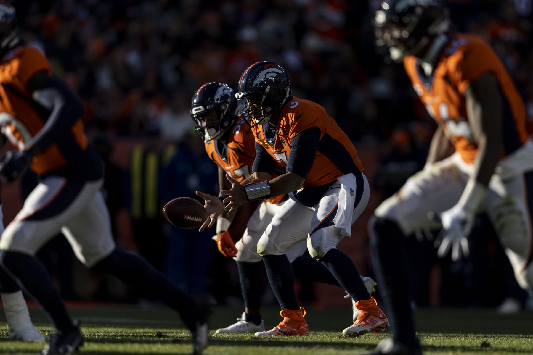 DENVER, COLORADO - NOVEMBER 26: Russell Wilson #3 of the Denver Broncos hikes the ball during an NFL football game between the Denver Broncos and the Cleveland Browns at Empower Field At Mile High on November 26, 2023 in Denver, Colorado. (Photo by Michael Owens/Getty Images)