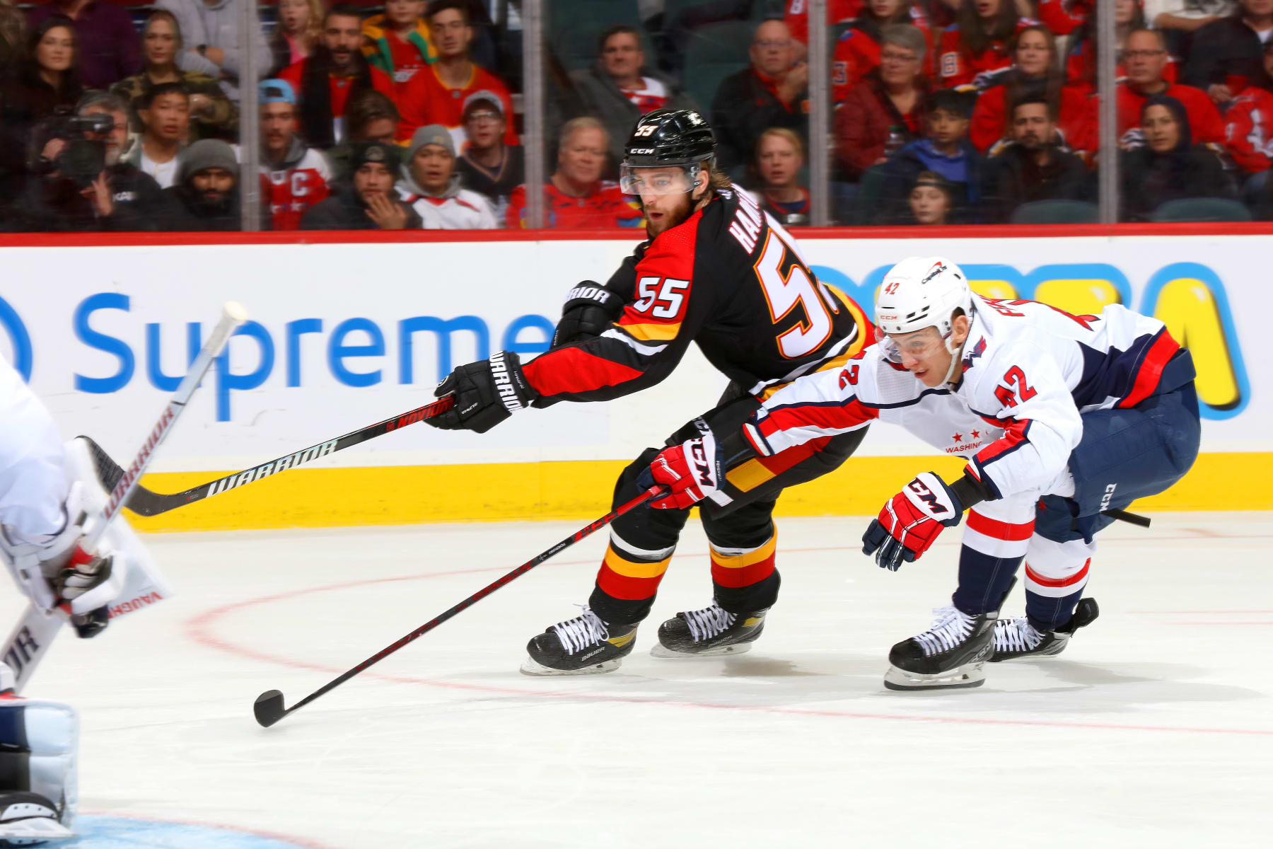 CALGARY, ALBERTA - DECEMBER 03: Noah Hanifin #55 of the Calgary Flames skates against Martin Fehervary #42 of the Washington Capitals at Scotiabank Saddledome on December 03, 2022 in Calgary, Alberta. (Photo by Gerry Thomas/NHLI via Getty Images)