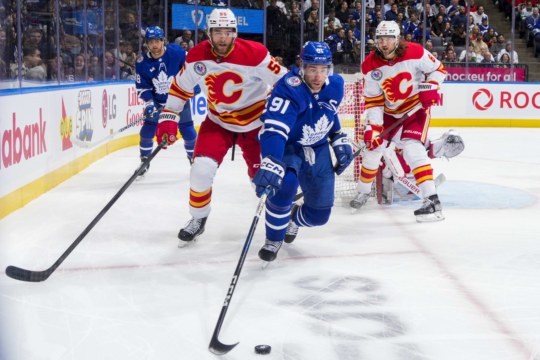 TORONTO, ON - NOVEMBER 10: John Tavares #91 of the Toronto Maple Leafs plays the puck agaistn Noah Hanifin #55 of the Calgary Flames during the first period at the Scotiabank Arena on November 10, 2023 in Toronto, Ontario, Canada. (Photo by Mark Blinch/NHLI via Getty Images)