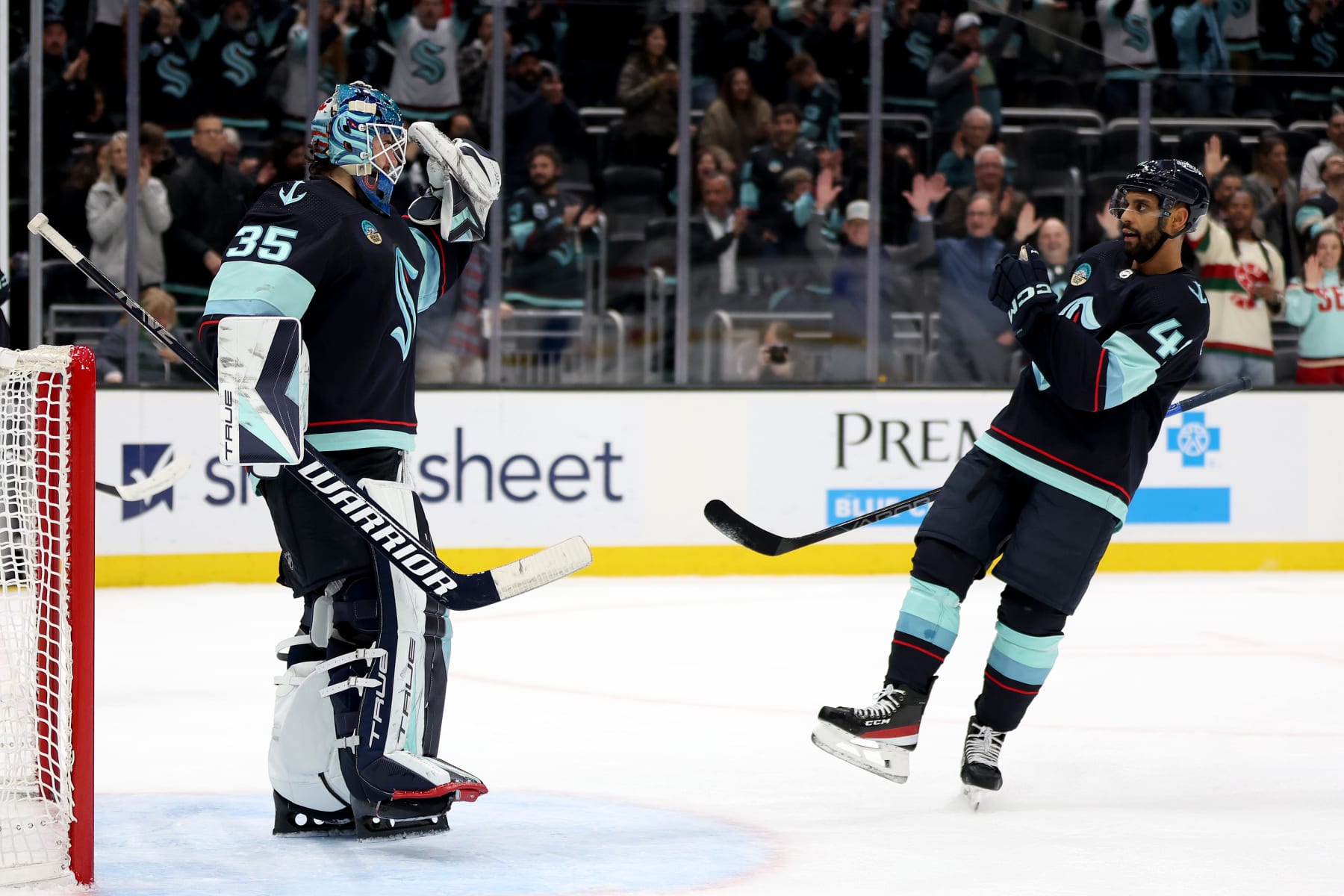 SEATTLE, WASHINGTON - DECEMBER 12: Joey Daccord #35 of the Seattle Kraken celebrates his first NHL shutout with Pierre-Edouard Bellemare #41 against Florida Panthers at Climate Pledge Arena on December 12, 2023 in Seattle, Washington. (Photo by Steph Chambers/Getty Images)
