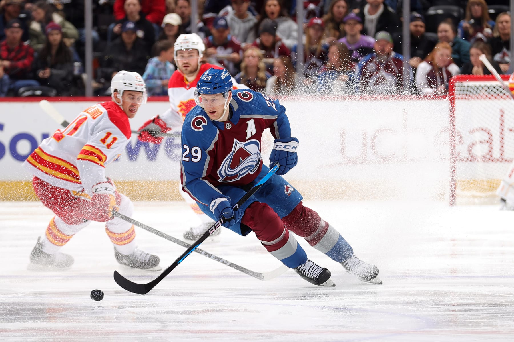 DENVER, COLORADO - DECEMBER 11: Nathan MacKinnon #29 of the Colorado Avalanche skates against Mikael Backlund #11 of the Calgary Flames at Ball Arena on December 11, 2023 in Denver, Colorado. (Photo by Michael Martin/NHLI via Getty Images)