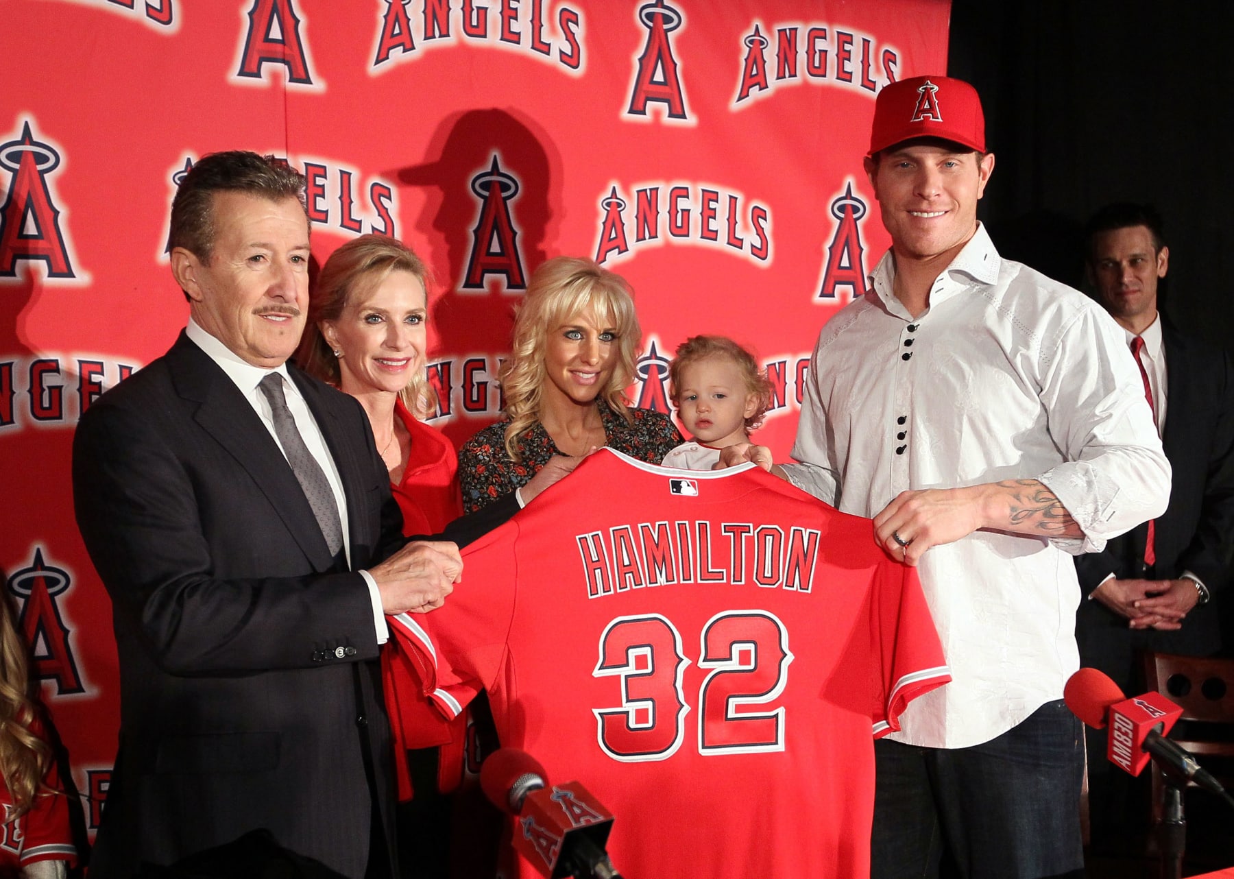 ANAHEIM, CA - DECEMBER 15: Josh Hamilton #32 of the Los Angeles Angels of Anaheim (R) holds up his new jersey with Angels Owner Arte Moreno during the press conference introducing Hamilton as the team's newest player as wife Katie, daughter Stella Faith and Carole Moreno look on from the background at ESPN Zone at Downtown Disney on December 15, 2012 in Anaheim, California. (Photo by Victor Decolongon/Getty Images)