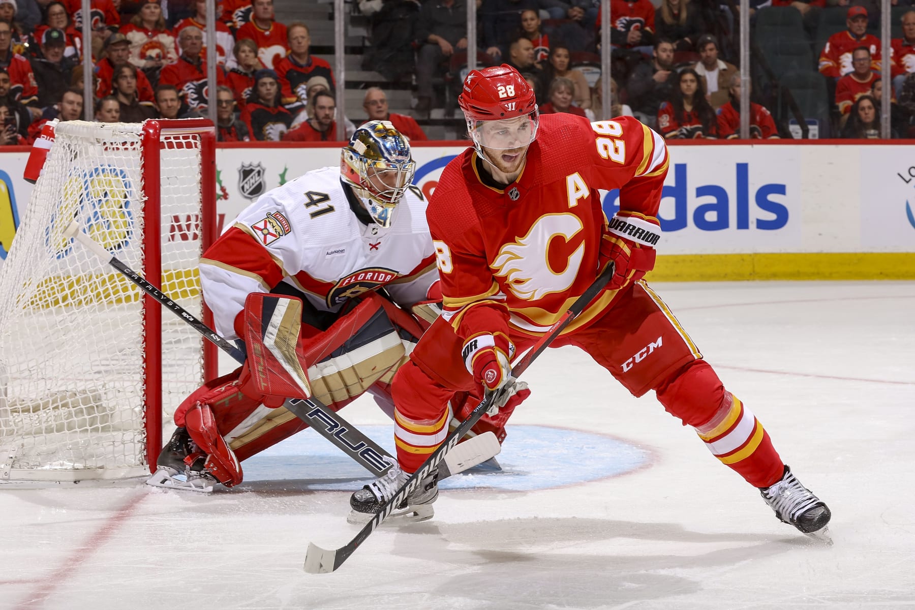 CALGARY, AB - DECEMBER 18: Elias Lindholm #28 of the Calgary Flames battles in front of the net against the Florida Panthers at Scotiabank Saddledome on December 18, 2023 in Calgary, Alberta, Canada. (Photo by Gerry Thomas/NHLI via Getty Images)