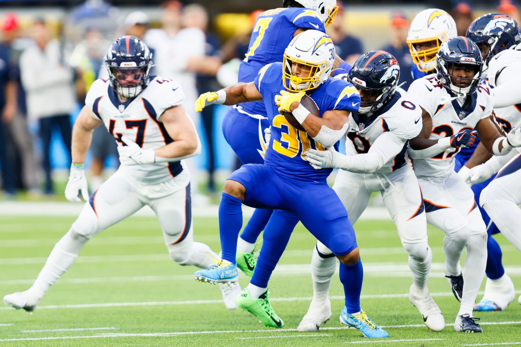 Inglewood, CA - December 10: Los Angeles Chargers running back Austin Ekeler (30) runs the ball while Denver Broncos linebacker Jonathon Cooper (0) attempts a tackle during the second half at SoFi Stadium in Inglewood Sunday, Dec. 10, 2023. (Allen J. Schaben / Los Angeles Times via Getty Images)