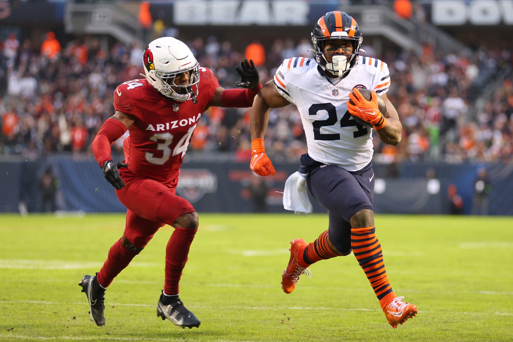 CHICAGO, ILLINOIS - DECEMBER 24: Khalil Herbert #24 of the Chicago Bears runs past Jalen Thompson #34 of the Arizona Cardinals for a second quarter touchdown at Soldier Field on December 24, 2023 in Chicago, Illinois. (Photo by Michael Reaves/Getty Images)