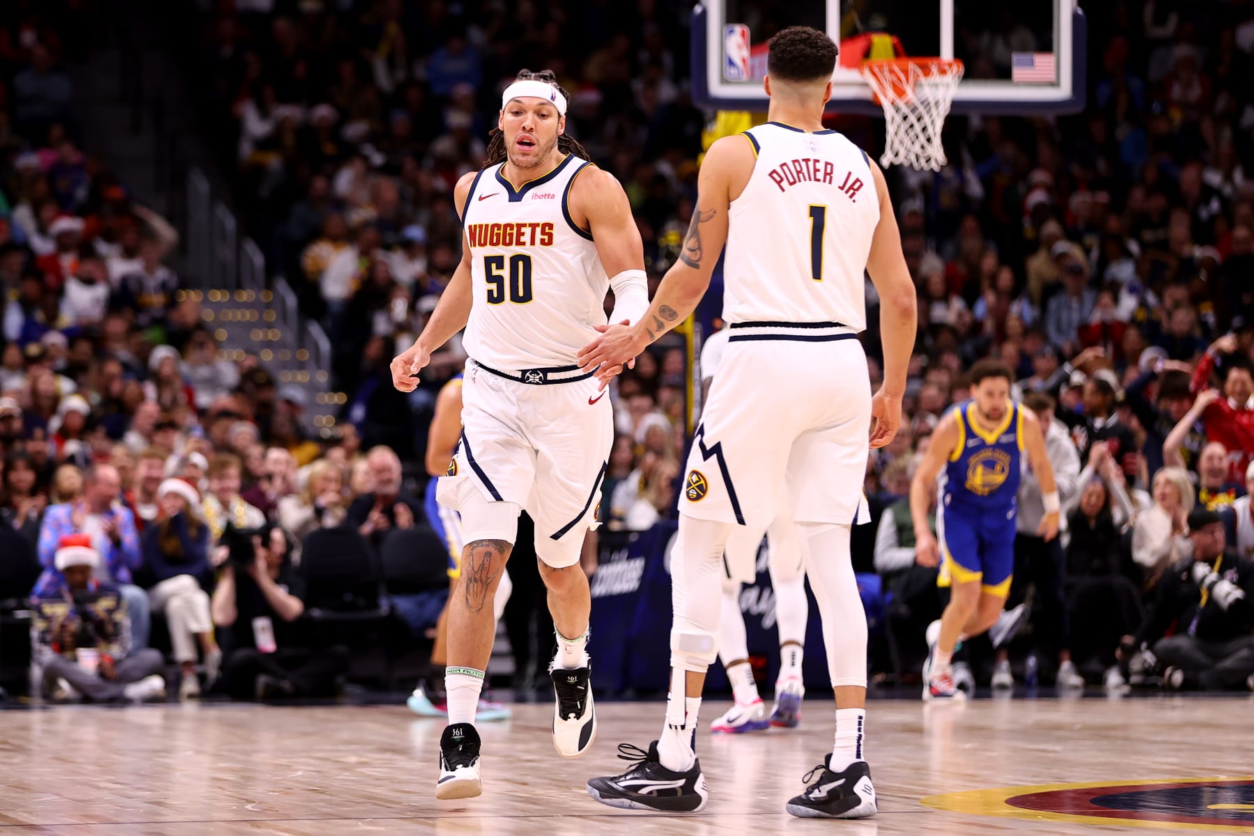 DENVER, COLORADO - DECEMBER 25: Aaron Gordon #50 and Michael Porter Jr. #1 of the Denver Nuggets high five against the Golden State Warriors at Ball Arena on December 25, 2023 in Denver, Colorado. NOTE TO USER: User expressly acknowledges and agrees that, by downloading and/or using this Photograph, user is consenting to the terms and conditions of the Getty Images License Agreement. (Photo by Jamie Schwaberow/Getty Images)