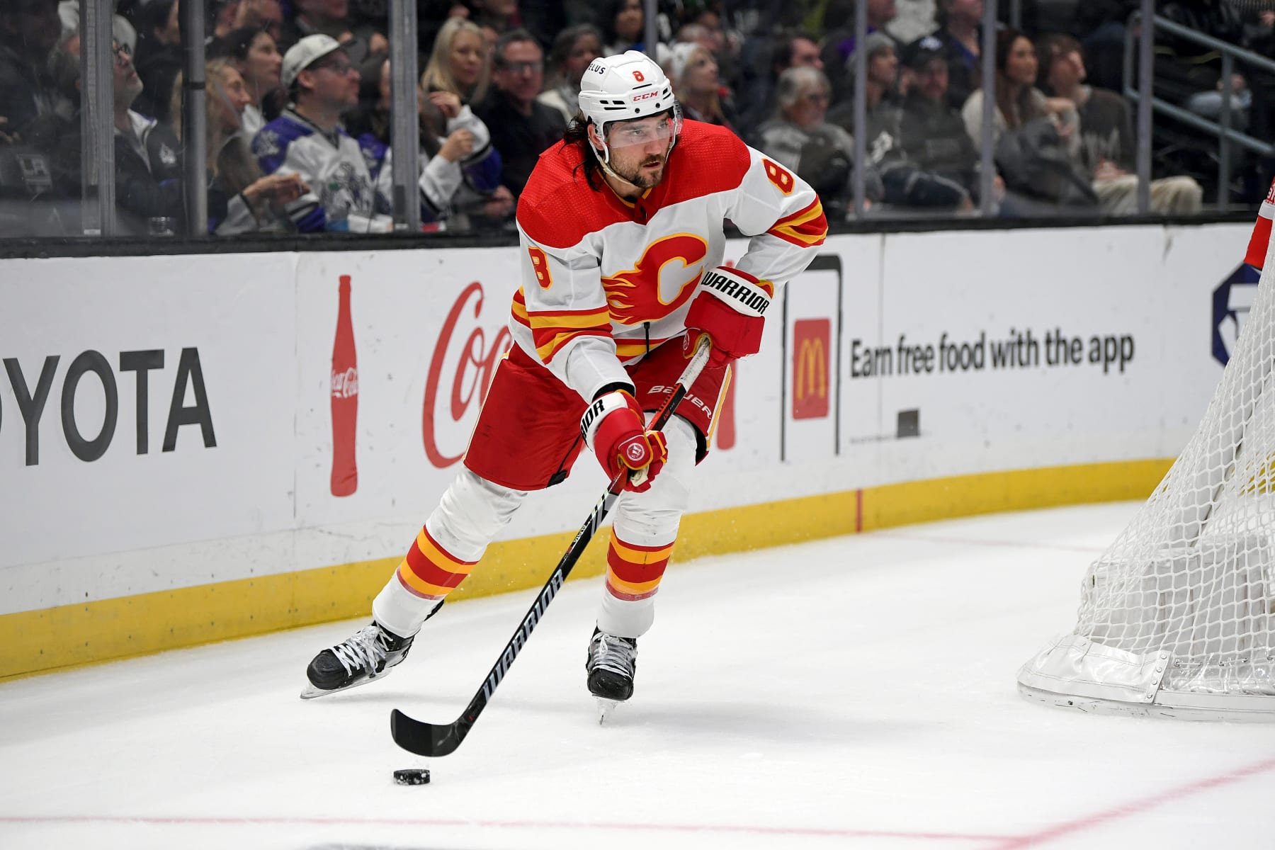 LOS ANGELES, CA - DECEMBER 23: Calgary Flames Defenceman Chris Tanev (8) carries the puck behind the Calgary net during a game between the Calgary Flames and the Los Angeles Kings on December 23, 2023 at the Crypto.com Arena in Los Angeles, CA. (Photo by Rob Curtis/Icon Sportswire via Getty Images)