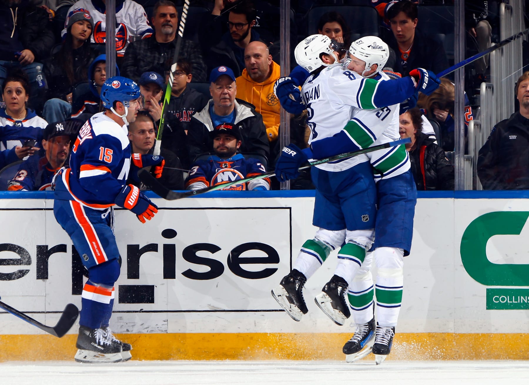 ELMONT, NEW YORK - JANUARY 09: Tyler Myers #57 of the Vancouver Canucks scores at 17:54 of the second period against the New York Islanders and is joined by Conor Garland #8 at UBS Arena on January 09, 2024 in Elmont, New York. (Photo by Bruce Bennett/Getty Images)
