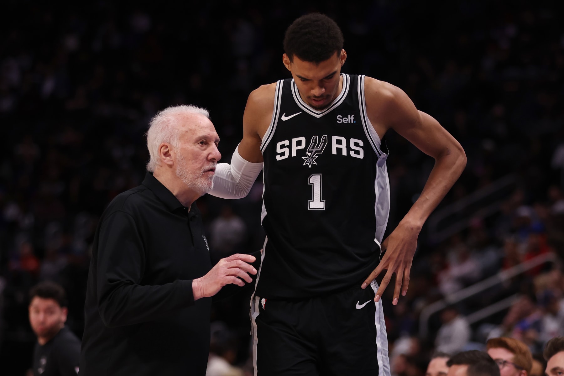 DETROIT, MICHIGAN - JANUARY 10: Head coach Gregg Popovich of the San Antonio Spurs talks to Victor Wembanyama #1 during the second half while playing the Detroit Pistons at Little Caesars Arena on January 10, 2024 in Detroit, Michigan. San Antonio Spurs won the game 130-108. NOTE TO USER: User expressly acknowledges and agrees that, by downloading and or using this photograph, User is consenting to the terms and conditions of the Getty Images License  (Photo by Gregory Shamus/Getty Images)