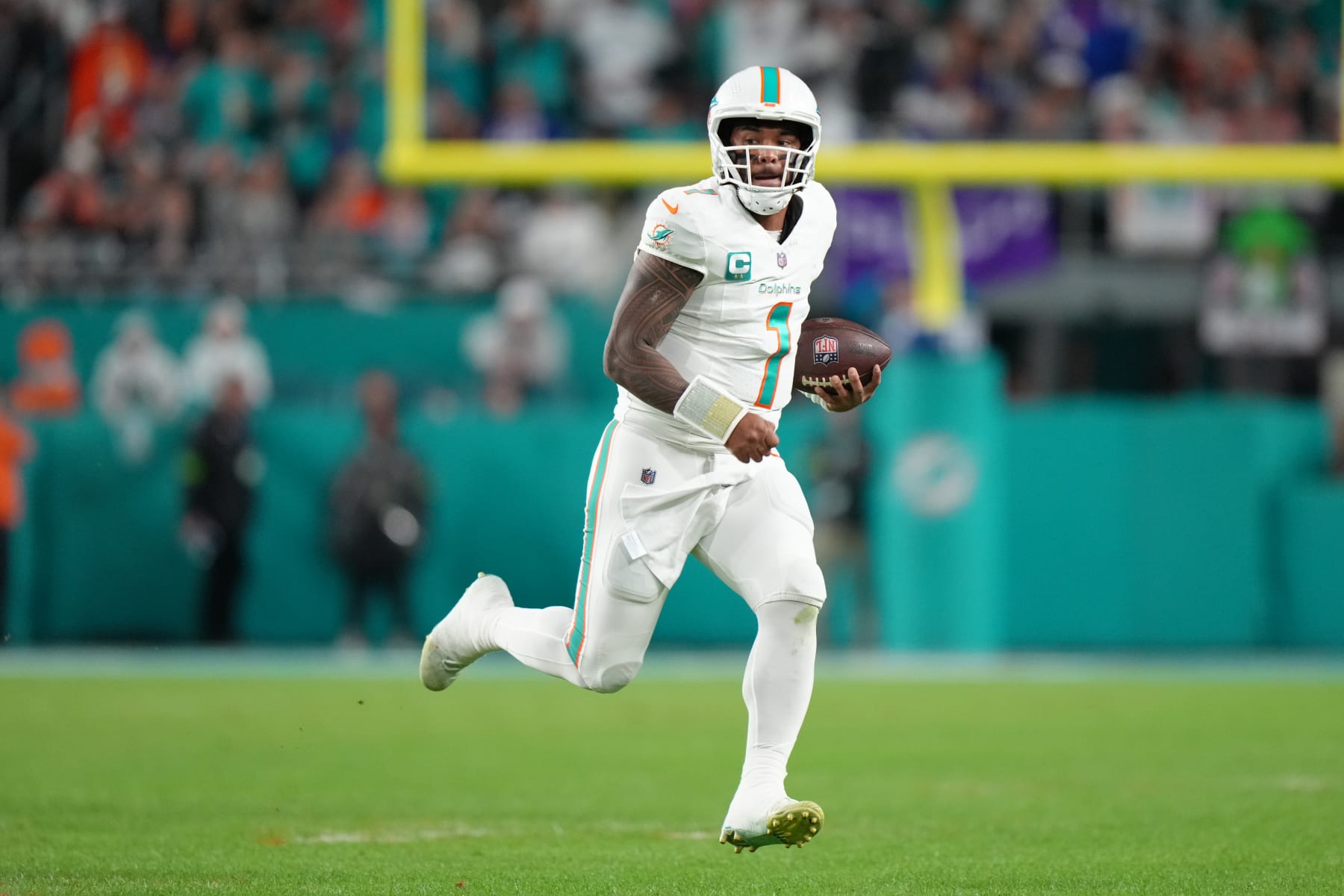 MIAMI GARDENS, FL - JANUARY 07: Miami Dolphins quarterback Tua Tagovailoa (1) scrambles for a first down in the first half during the game between the Buffalo Bills and the Miami Dolphins on Sunday, January 7, 2024 at Hard Rock Stadium, Miami Gardens, Fla. (Photo by Peter Joneleit/Icon Sportswire via Getty Images)