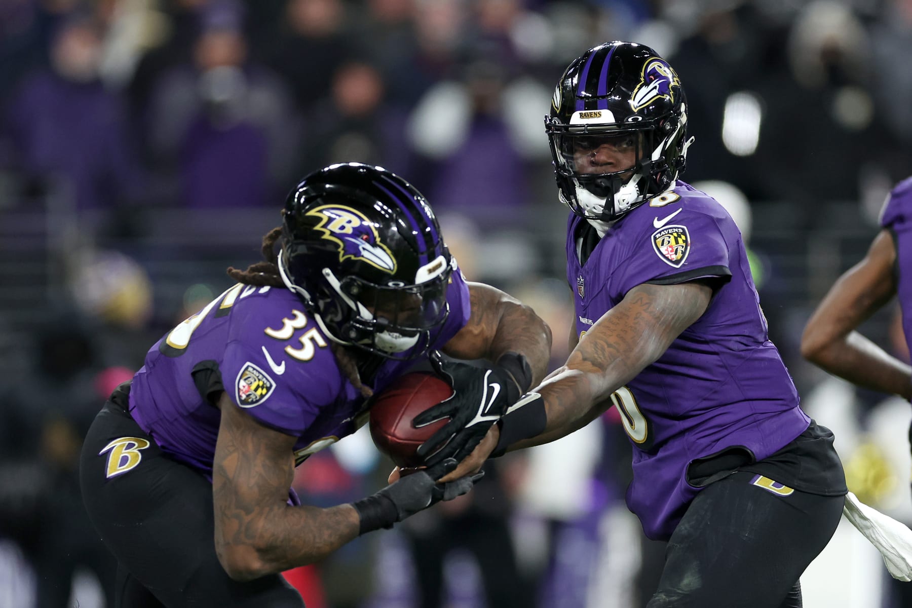 BALTIMORE, MARYLAND - JANUARY 20: Quarterback Lamar Jackson #8 hands the ball off to running back Gus Edwards #35 of the Baltimore Ravens against the Houston Texans during the AFC Divisional Playoff game at M&T Bank Stadium on January 20, 2024 in Baltimore, Maryland. (Photo by Rob Carr/Getty Images)