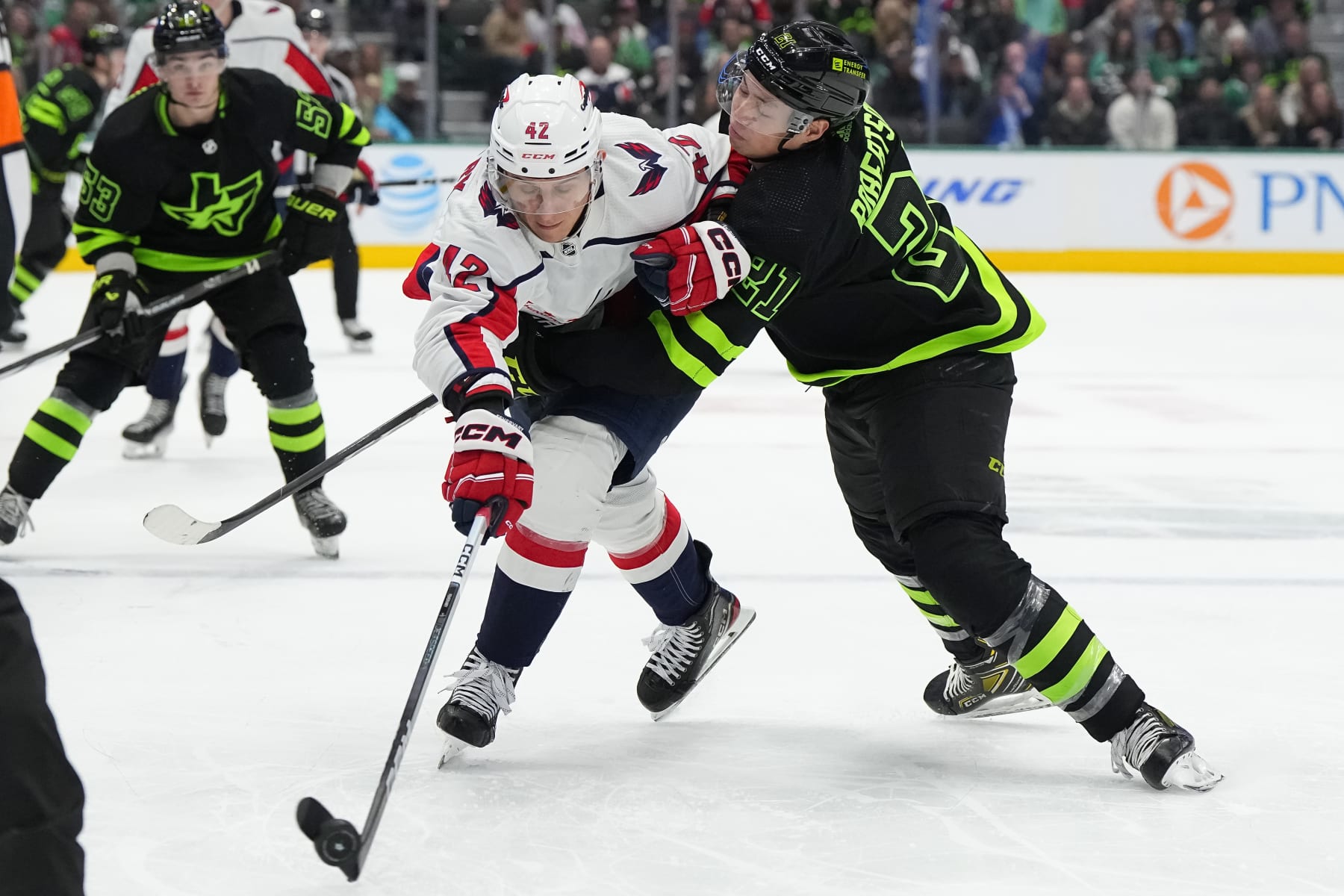 DALLAS, TEXAS - JANUARY 27: Martin Fehervary #42 of the Washington Capitals passes as he is hit by Jason Robertson #21 of the Dallas Stars during the third period at American Airlines Center on January 27, 2024 in Dallas, Texas. (Photo by Sam Hodde/Getty Images)