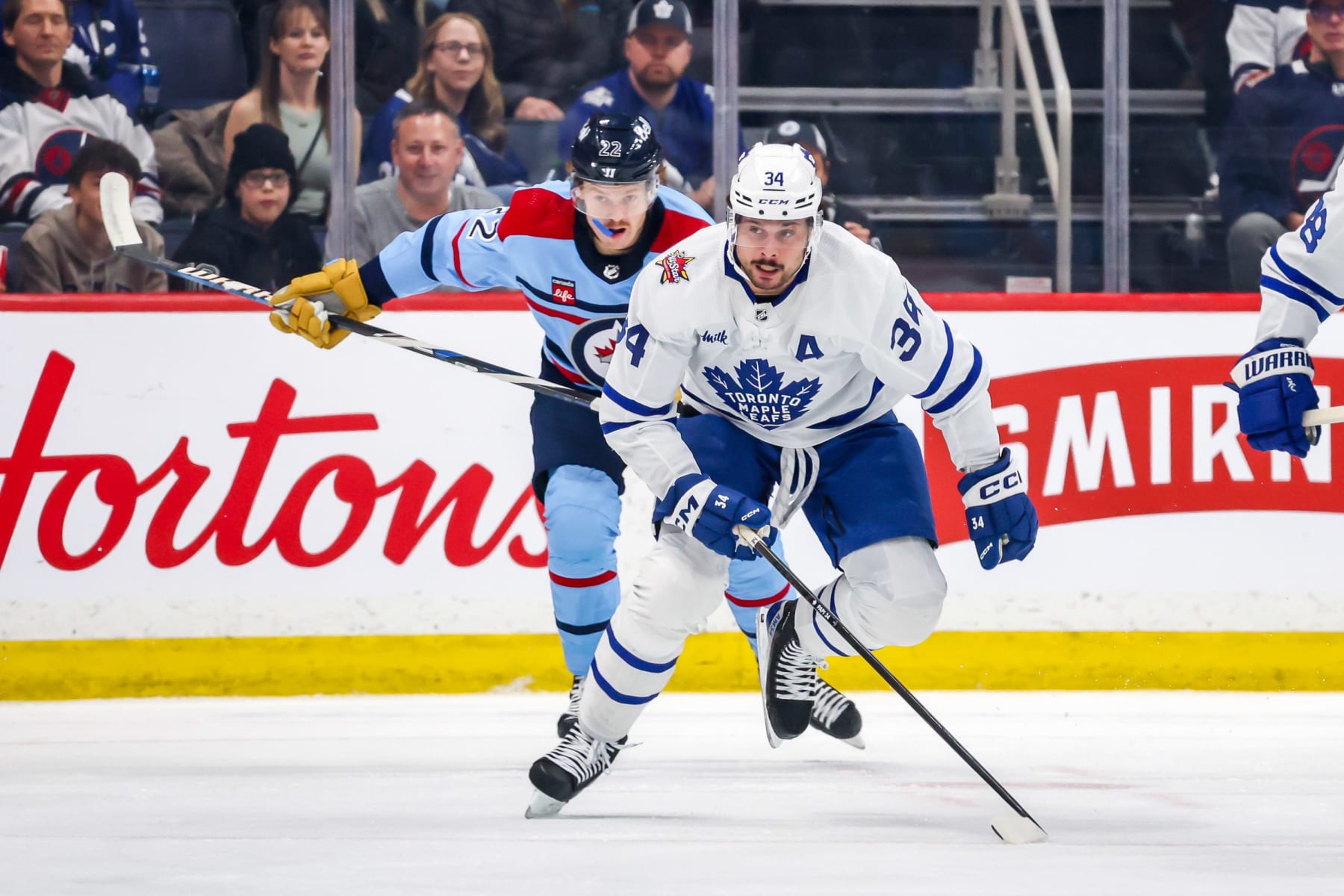 WINNIPEG, CANADA - JANUARY 27: Auston Matthews #34 of the Toronto Maple Leafs and Mason Appleton #22 of the Winnipeg Jets follow the play up the ice during first period action at the Canada Life Centre on January 27, 2024 in Winnipeg, Manitoba, Canada. (Photo by Jonathan Kozub/NHLI via Getty Images)
