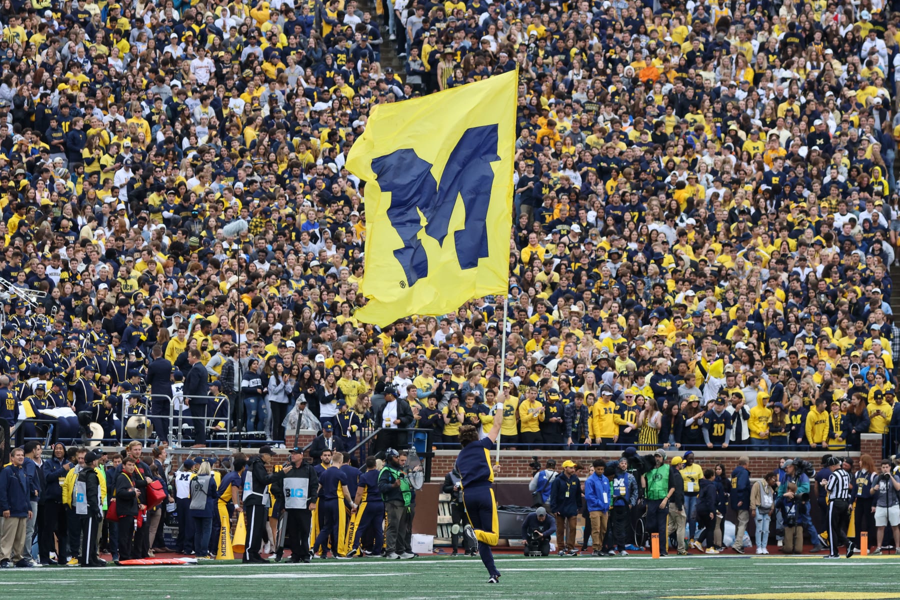 ANN ARBOR, MI - SEPTEMBER 24: A Michigan cheerleader runs down the field with a flag with the Michigan block "M" logo after Michigan scored a touchdown during the first quarter of a Big Ten Conference regular season college football game between the Maryland Terrapins and the Michigan Wolverines on September 24, 2022 at Michigan Stadium in Ann Arbor, Michigan. (Photo by Scott W. Grau/Icon Sportswire via Getty Images)