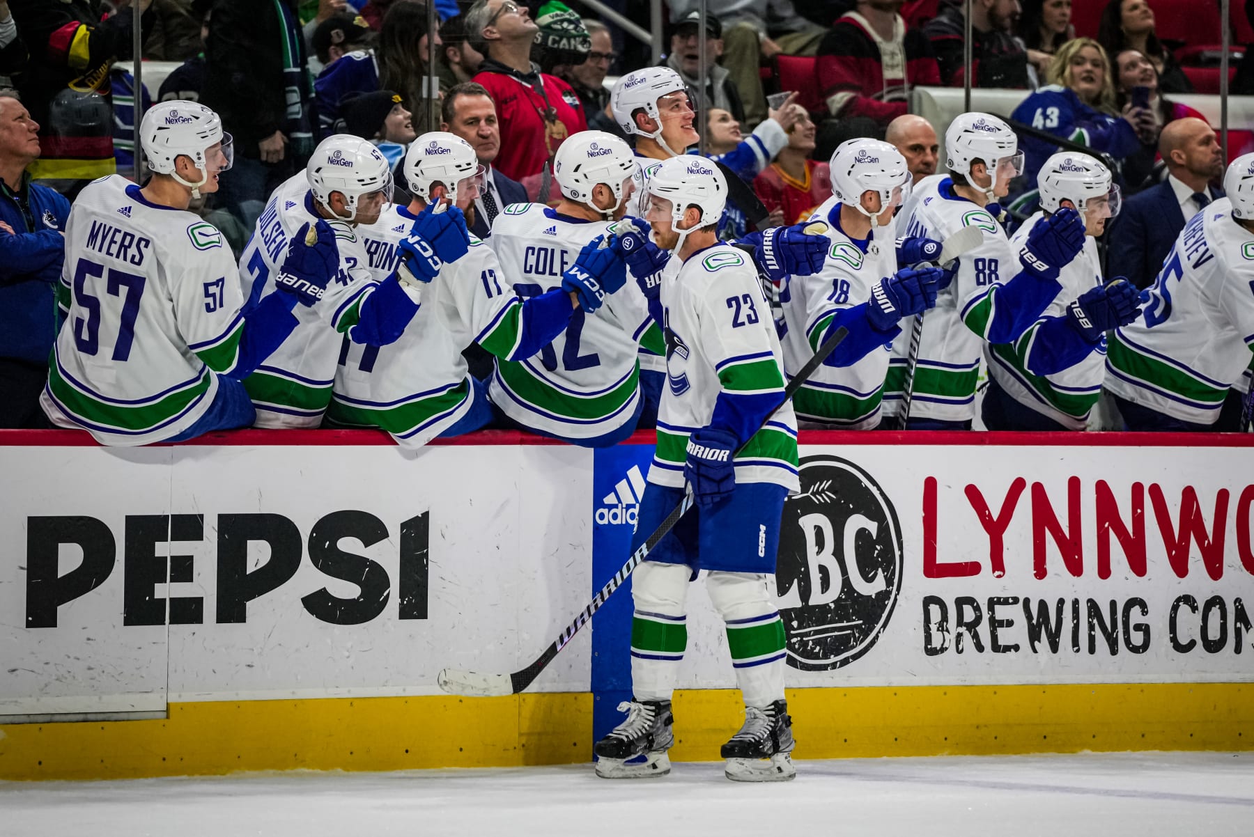 RALEIGH, NORTH CAROLINA - FEBRUARY 06: Elias Lindholm #23 of the Vancouver Canucks celebrates with teammates after scoring a goal during the first period against the Carolina Hurricanes at PNC Arena on February 06, 2024 in Raleigh, North Carolina. (Photo by Josh Lavallee/NHLI via Getty Images)