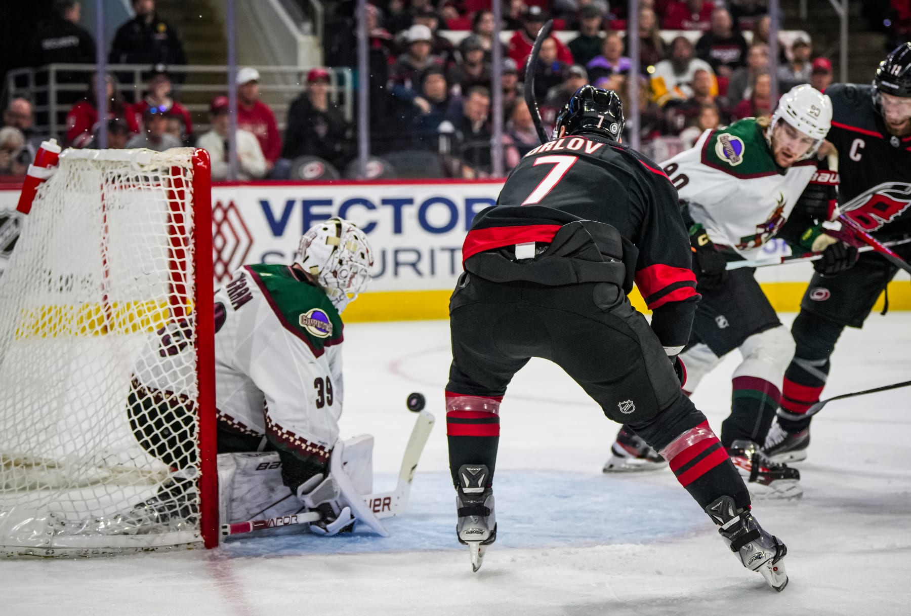 RALEIGH, NORTH CAROLINA - JANUARY 27: Connor Ingram #39 of the Arizona Coyotes makes a save against Dmitry Orlov #7 of the Carolina Hurricanes during the first period at PNC Arena on January 27, 2024 in Raleigh, North Carolina. (Photo by Josh Lavallee/NHLI via Getty Images)