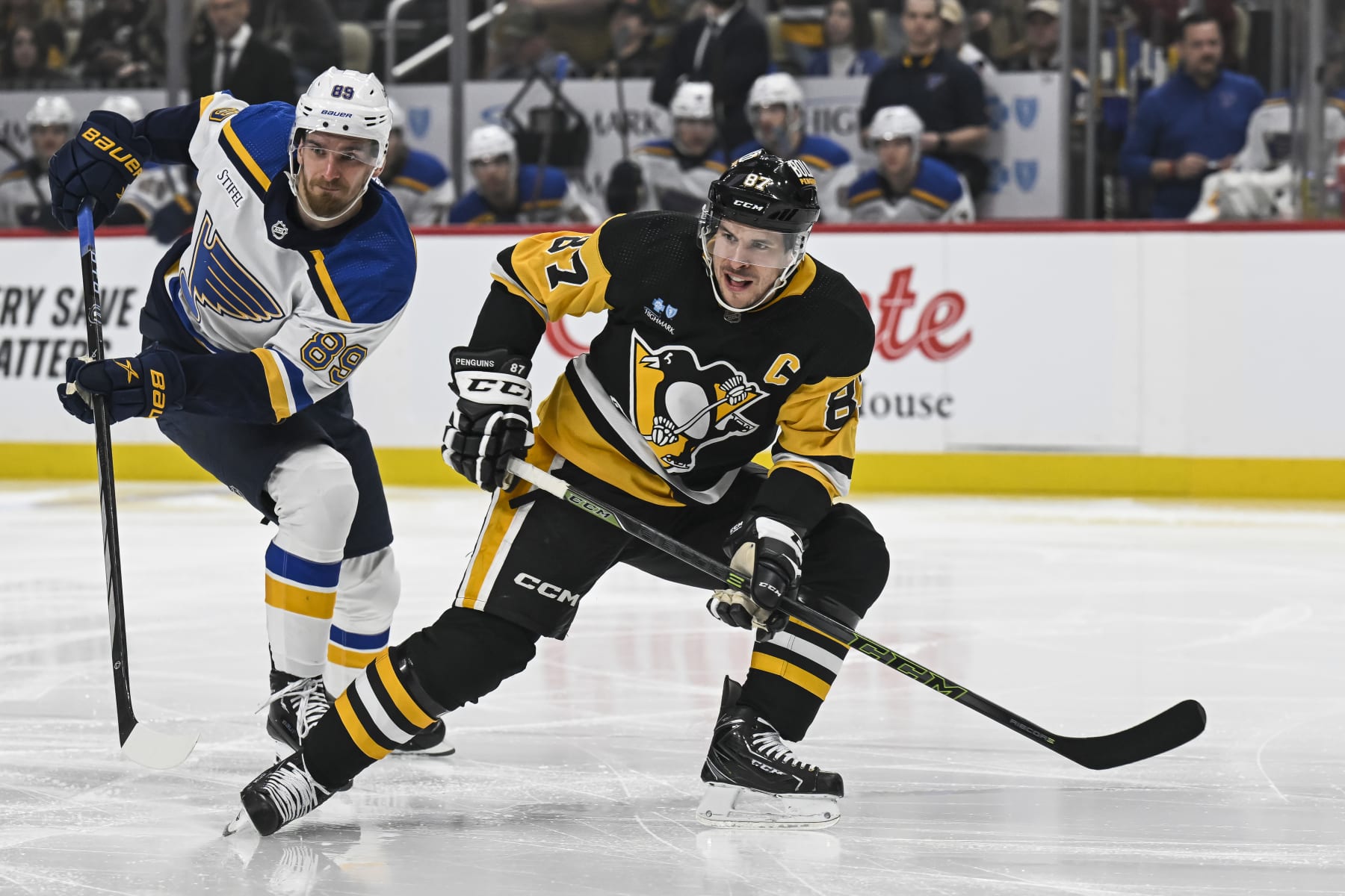 PITTSBURGH, PA - DECEMBER 30: Pittsburgh Penguins center Sidney Crosby (87) looks for a pass as St. Louis Blues left wing Pavel Buchnevich (89) defends during the first period in the NHL game between the Pittsburgh Penguins and the St. Louis Blues on December 30, 2023, at PPG Paints Arena in Pittsburgh, PA. (Photo by Jeanine Leech/Icon Sportswire via Getty Images)