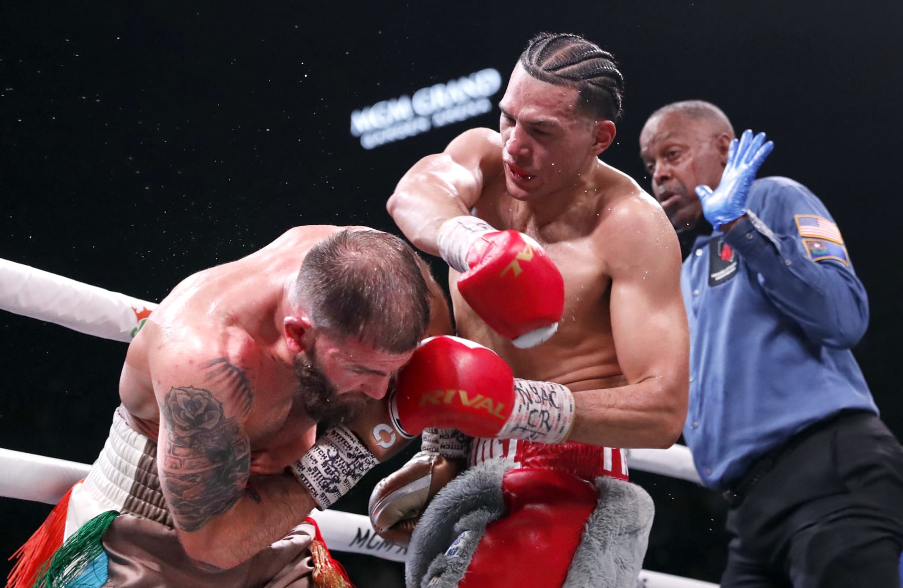 LAS VEGAS, NEVADA - MARCH 25: David Benavidez (C) punches Caleb Plant as referee Kenny Bayless looks on during a WBC super middleweight fight at MGM Grand Garden Arena on March 25, 2023 in Las Vegas, Nevada. Benavidez retained his WBC interim super middleweight title by unanimous decision. (Photo by Steve Marcus/Getty Images)