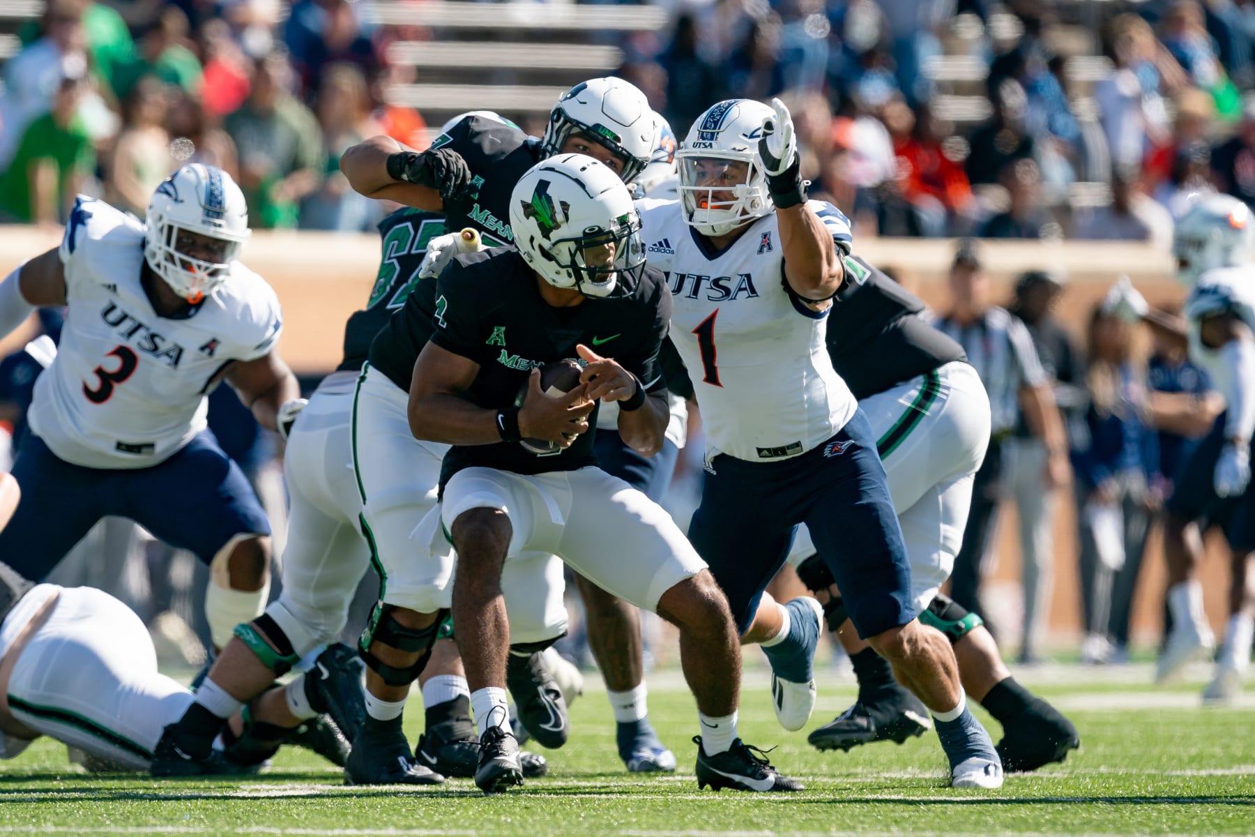 DENTON, TX - NOVEMBER 04: North Texas Mean Green quarterback Chandler Rogers (4) is pressured by UTSA Roadrunners linebacker Trey Moore (1) during the UTSA Roadrunners and North Texas Mean Green on November 4, 2023 at Apogee Stadium, TX. (Photo by Christopher Leduc/Icon Sportswire via Getty Images)