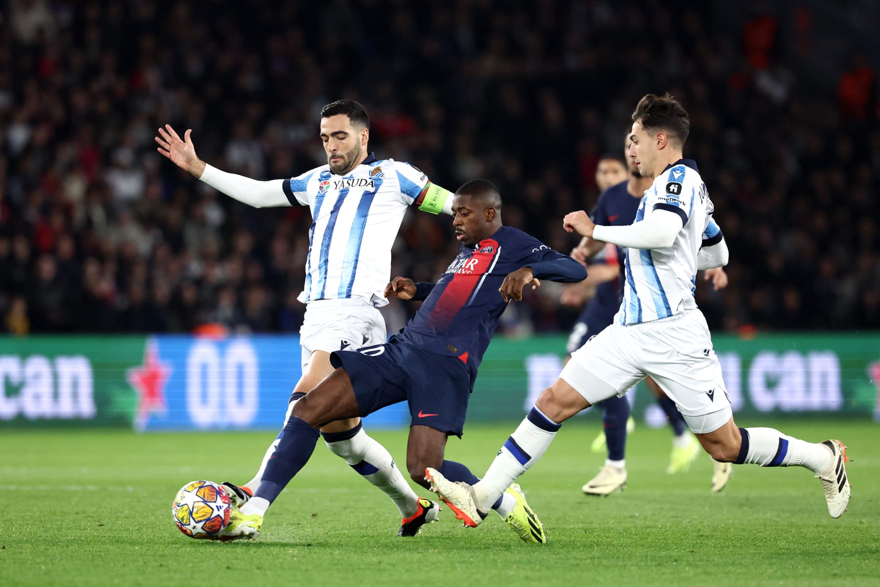 Paris Saint-Germain's French forward #10 Ousmane Dembele (C) fights for the ball with Real Sociedad's Spanish midfielder #08 Mikel Merino (L) during the UEFA Champions League round of 16 first leg football match between Paris Saint-Germain (PSG) and Real Sociedad at the Parc des Princes Stadium in Paris, on February 14, 2024. (Photo by FRANCK FIFE / AFP) (Photo by FRANCK FIFE/AFP via Getty Images)