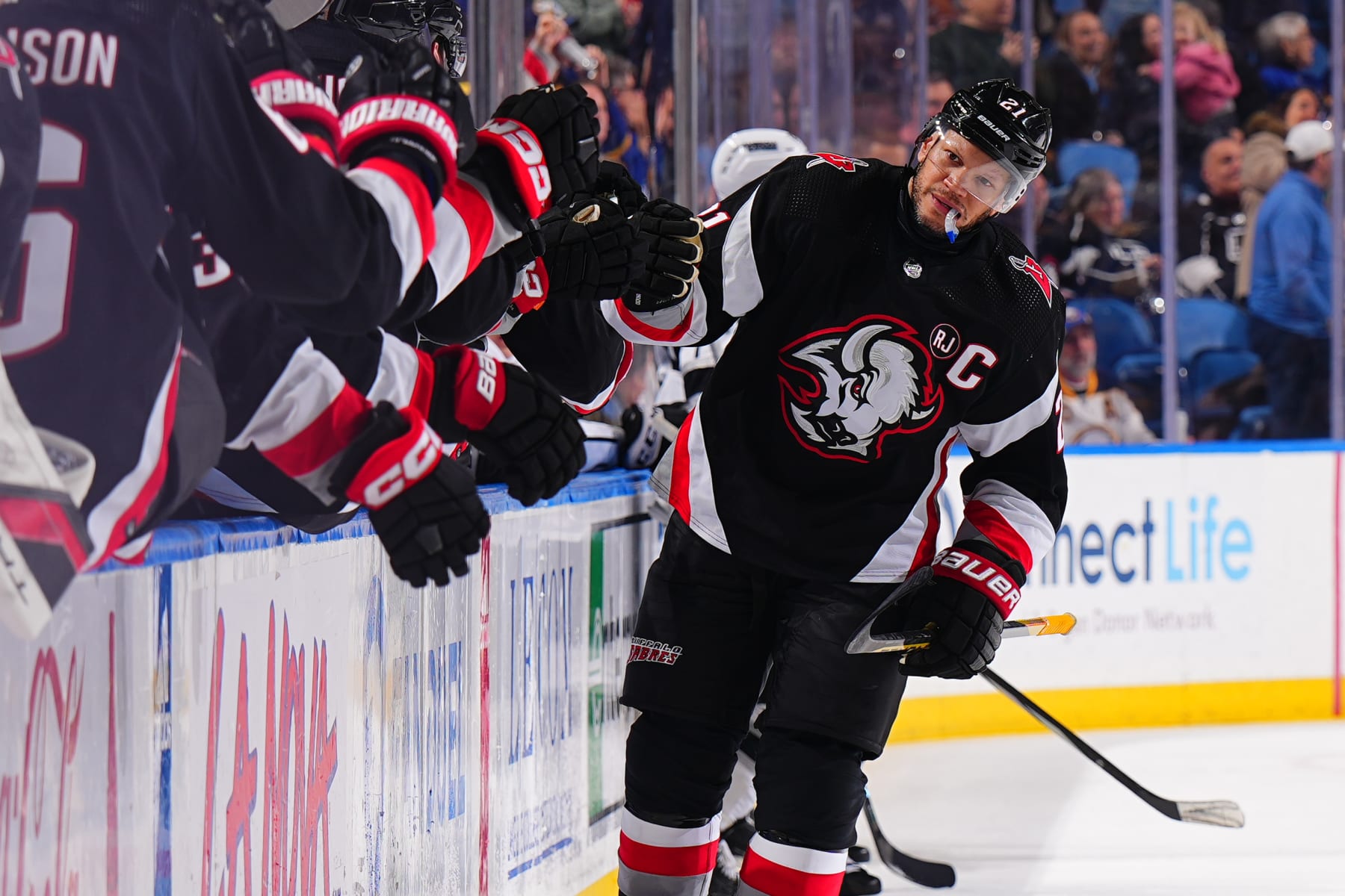 BUFFALO, NEW YORK - FEBRUARY 13: Kyle Okposo #21 of the Buffalo Sabres celebrates his first period goal with teammates on the bench during an NHL game against the Los Angeles Kings on February 13, 2024 at KeyBank Center in Buffalo, New York. (Photo by Ben Ludeman/NHLI via Getty Images)