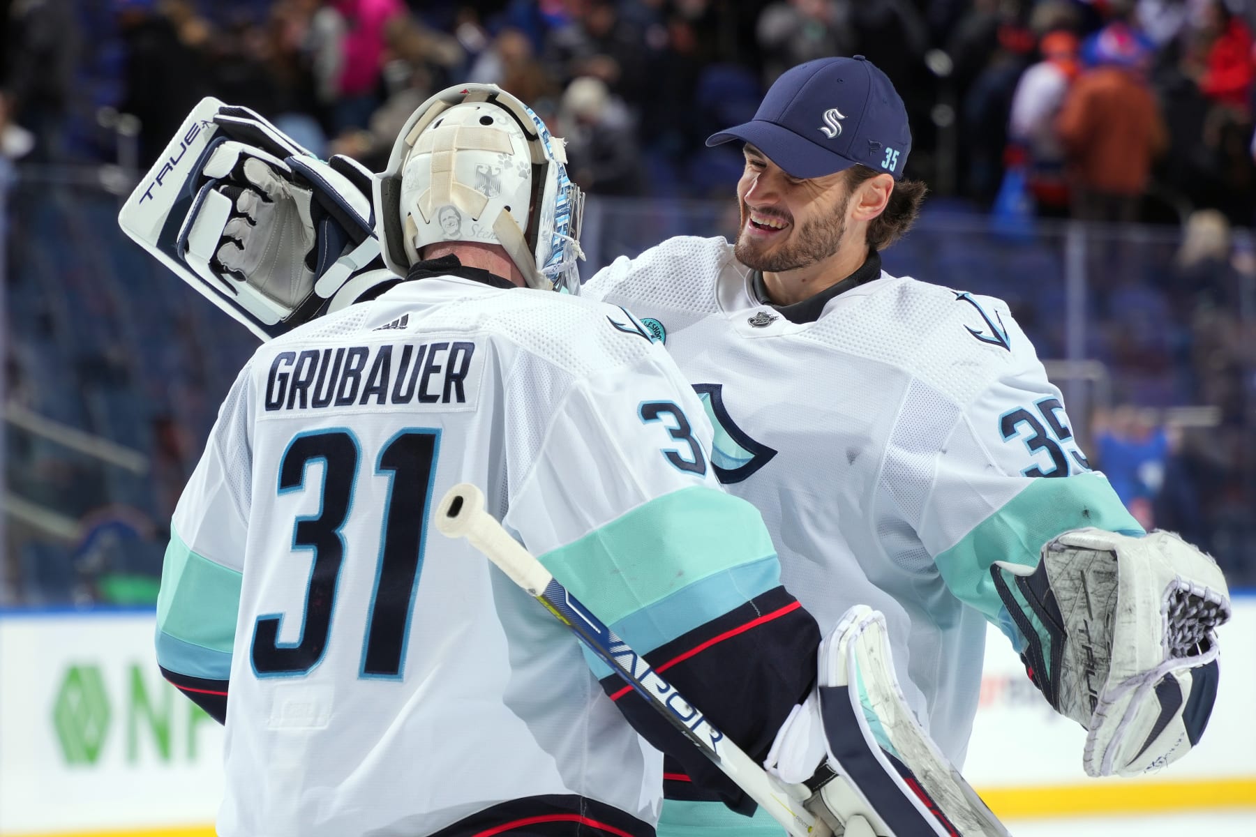 ELMONT, NEW YORK - FEBRUARY 13: Philipp Grubauer #31 of the Seattle Kraken and Joey Daccord #35 celebrate the 2-1 overtime shootout win against the New York Islanders at UBS Arena on February 13, 2024 in Elmont, New York. (Photo by Mike Stobe/NHLI via Getty Images)