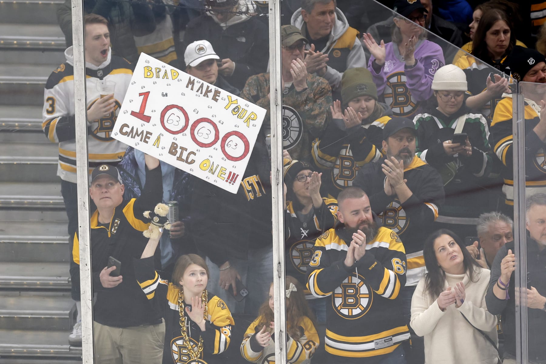 Boston, MA - February 13: A Boston Bruins fan holds up a sign celebrating Brad Marchand's 1,000th game with the team. The Bruins lost to the Tampa Bay Lightning, 3-2, in a shootout. (Photo by Danielle Parhizkaran/The Boston Globe via Getty Images)