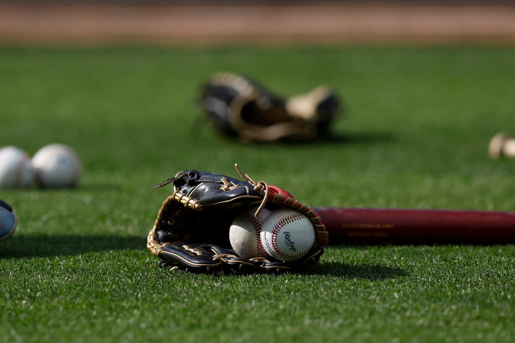 OAKLAND, CALIFORNIA - JUNE 12: Gloves, bats and baseballs sit on the field before the game between the Oakland Athletics and the Tampa Bay Rays at RingCentral Coliseum on June 12, 2023 in Oakland, California. (Photo by Lachlan Cunningham/Getty Images)