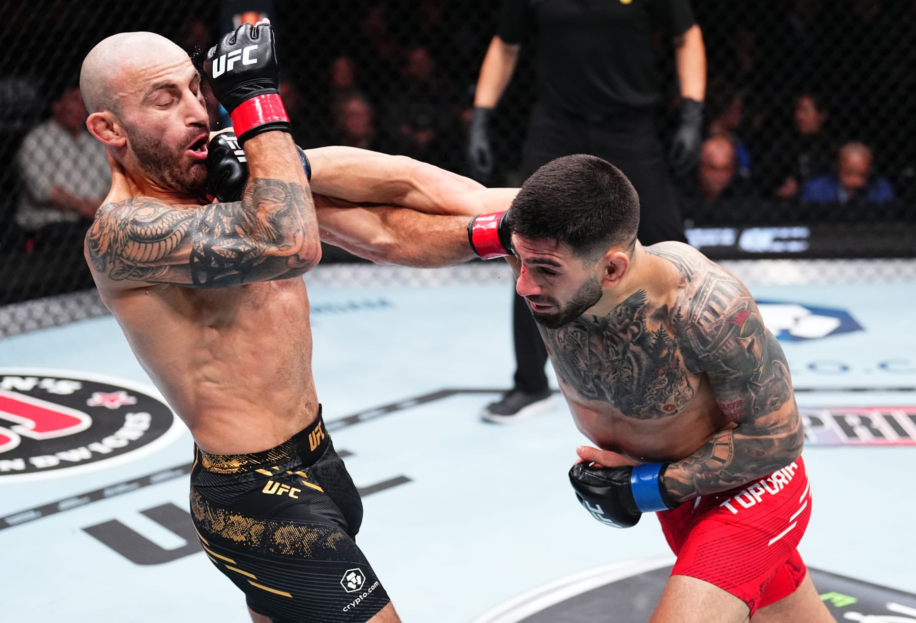 ANAHEIM, CALIFORNIA - FEBRUARY 17: (R-L) Ilia Topuria of Germany punches Alexander Volkanovski of Australia in the UFC featherweight championship fight during the UFC 298 event at Honda Center on February 17, 2024 in Anaheim, California. (Photo by Chris Unger/Zuffa LLC via Getty Images)