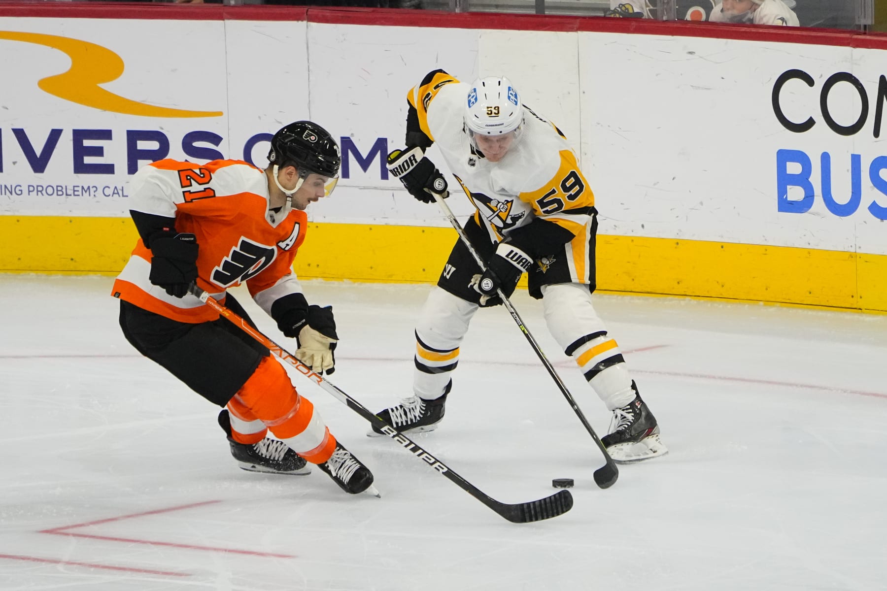 PHILADELPHIA, PA - JANUARY 06: Philadelphia Flyers Left Wing Scott Laughton (21) and Pittsburgh Penguins Left Wing Jake Guentzel (59) battle for the puck during the third period of the National Hockey League game between the Pittsburgh Penguins and the Philadelphia Flyers on January 6, 2022, at the Wells Fargo Center in Philadelphia, PA. (Photo by Gregory Fisher/Icon Sportswire via Getty Images)