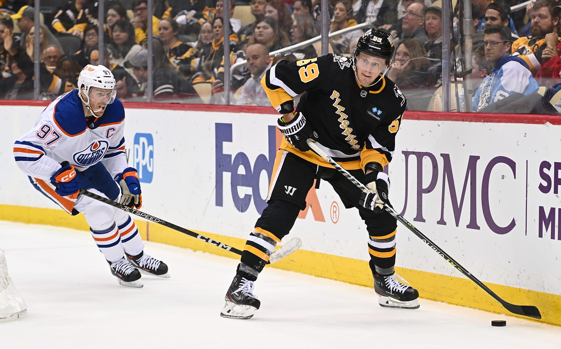 PITTSBURGH, PA - FEBRUARY 23: Jake Guentzel #59 of the Pittsburgh Penguins looks to move the puck under pressure from Connor McDavid #97 of the Edmonton Oilers in the third period during the game at PPG PAINTS Arena on February 23, 2023 in Pittsburgh, Pennsylvania. (Photo by Justin Berl/Getty Images)