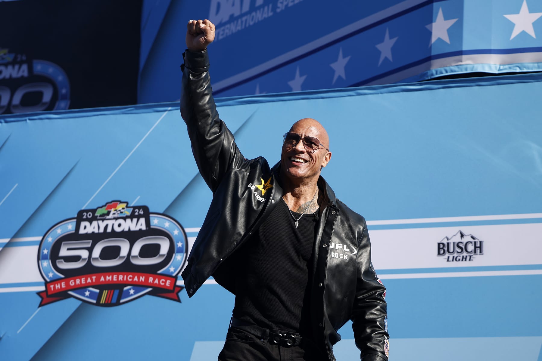 DAYTONA BEACH, FLORIDA - FEBRUARY 19: Grand Marshal Dwayne “The Rock” Johnson waves to fans as he walks onstage during pre-race ceremonies prior to the NASCAR Cup Series Daytona 500 at Daytona International Speedway on February 19, 2024 in Daytona Beach, Florida. (Photo by James Gilbert/Getty Images)