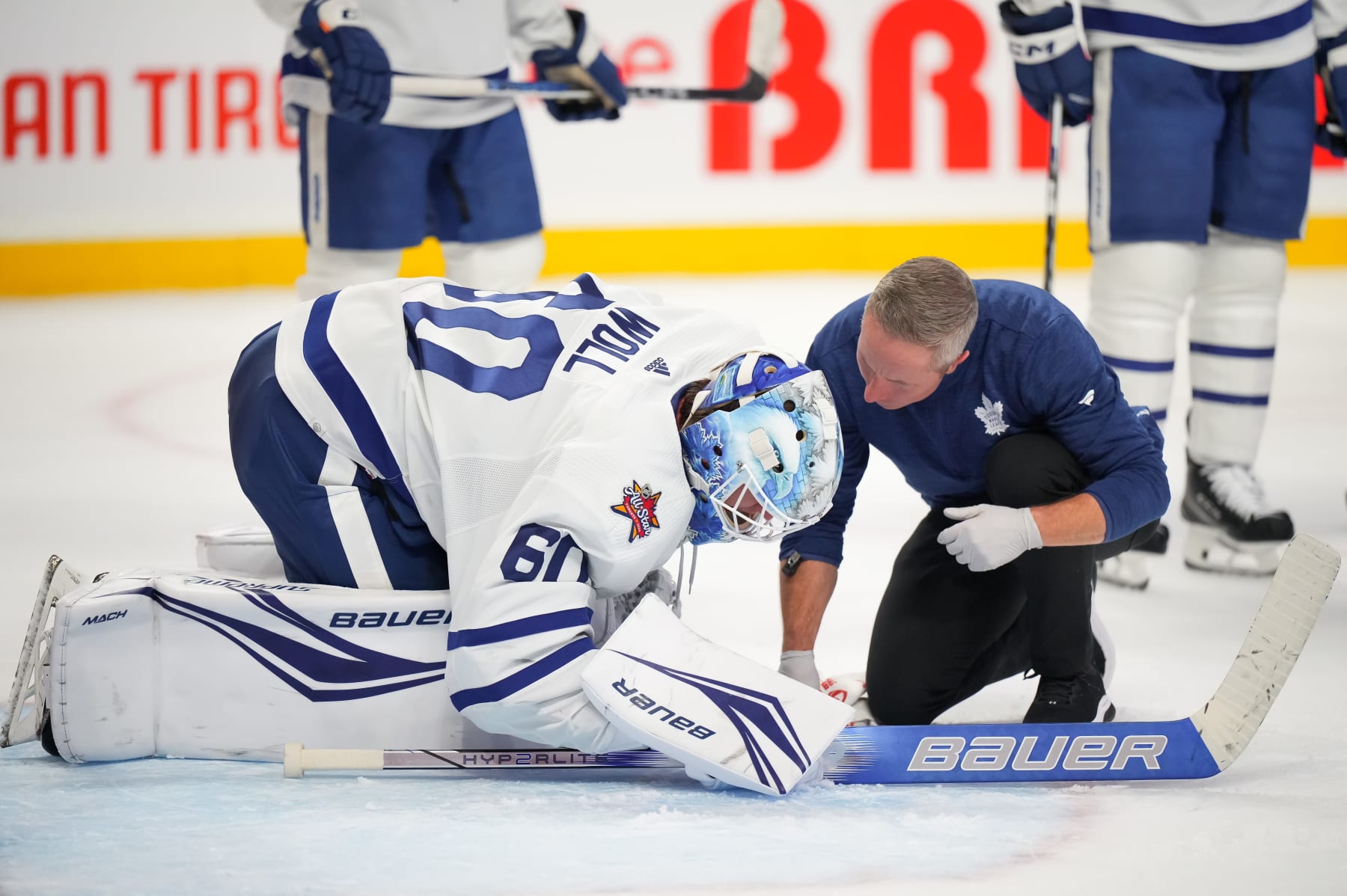 OTTAWA, CANADA - DECEMBER 7: Joseph Woll #60 of the Toronto Maple Leafs speaks to an athletic trainer during a stoppage in play after sustaining an injury against the Ottawa Senators during the third period at Canadian Tire Centre on December 7, 2023 in Ottawa, Ontario, Canada. (Photo by André Ringuette/NHLI via Getty Images)