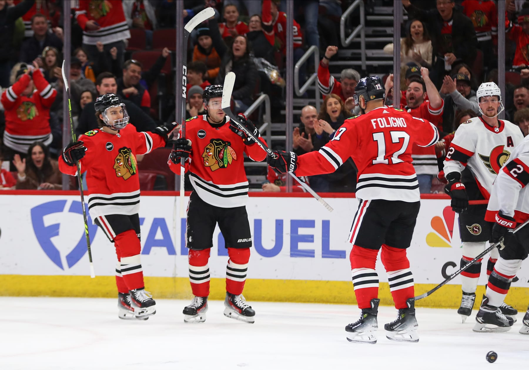 CHICAGO, IL - FEBRUARY 17: Connor Bedard #98 of the Chicago Blackhawks Philipp Kurashev #23 of the Chicago Blackhawks celebrate with Nick Foligno #17 of the Chicago Blackhawks after scoring a goal during the first period against the Ottawa Senators at the United Center on February 15, 2024 in Chicago, Illinois. (Photo by Melissa Tamez/Icon Sportswire via Getty Images)