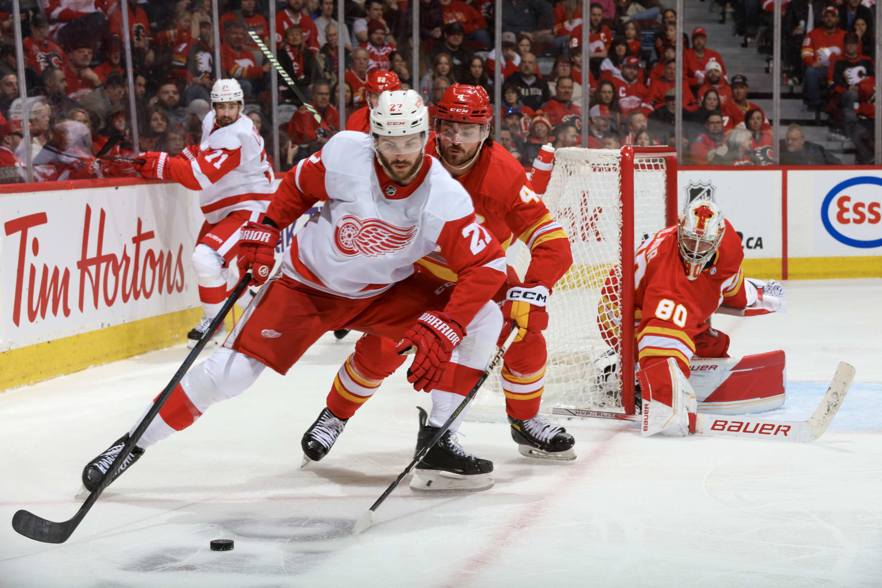 CALGARY, ALBERTA - FEBRUARY 17: Michael Rasmussen #27 of the Detroit Red Wings skates against Rasmus Andersson #4 of the Calgary Flames at the Scotiabank Saddledome on February 17, 2024 in Calgary, Alberta. (Photo by Gerry Thomas/NHLI via Getty Images)