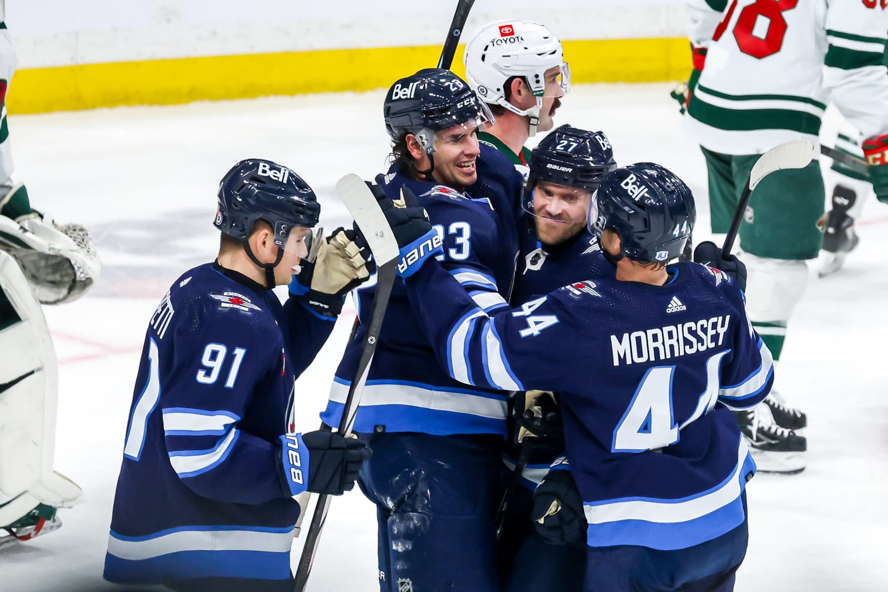 WINNIPEG, CANADA - FEBRUARY 20: Cole Perfetti #91, Sean Monahan #23, Nikolaj Ehlers #27 and Josh Morrissey #44 of the Winnipeg Jets celebrate a third period goal against the Minnesota Wild at the Canada Life Centre on February 20, 2024 in Winnipeg, Manitoba, Canada. (Photo by Jonathan Kozub/NHLI via Getty Images)