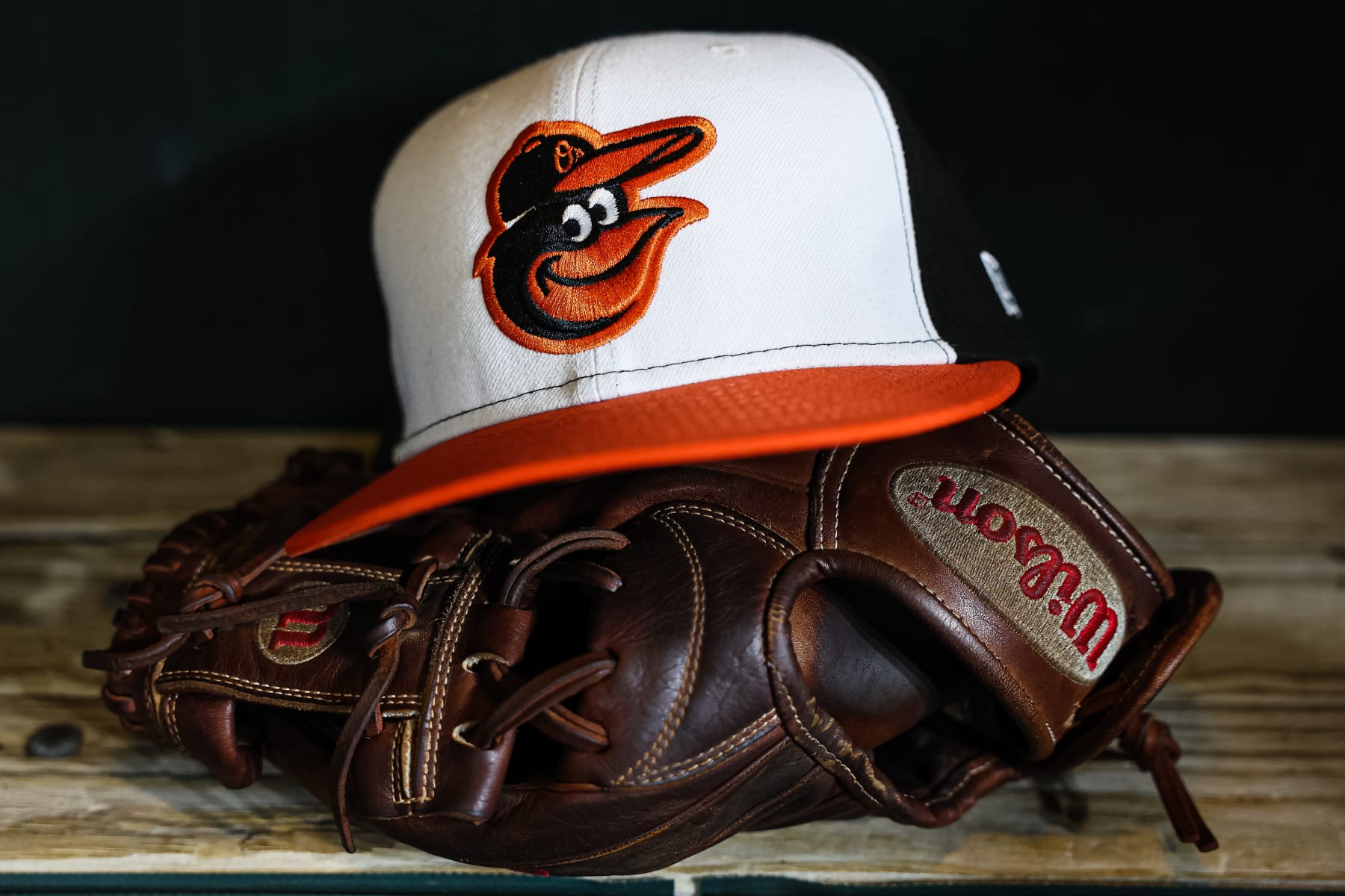 BALTIMORE, MD - APRIL 22: A general view of a Baltimore Orioles hat and glove in the dugout after the game against the Detroit Tigers at Oriole Park at Camden Yards on April 22, 2023 in Baltimore, Maryland. (Photo by Scott Taetsch/Getty Images)