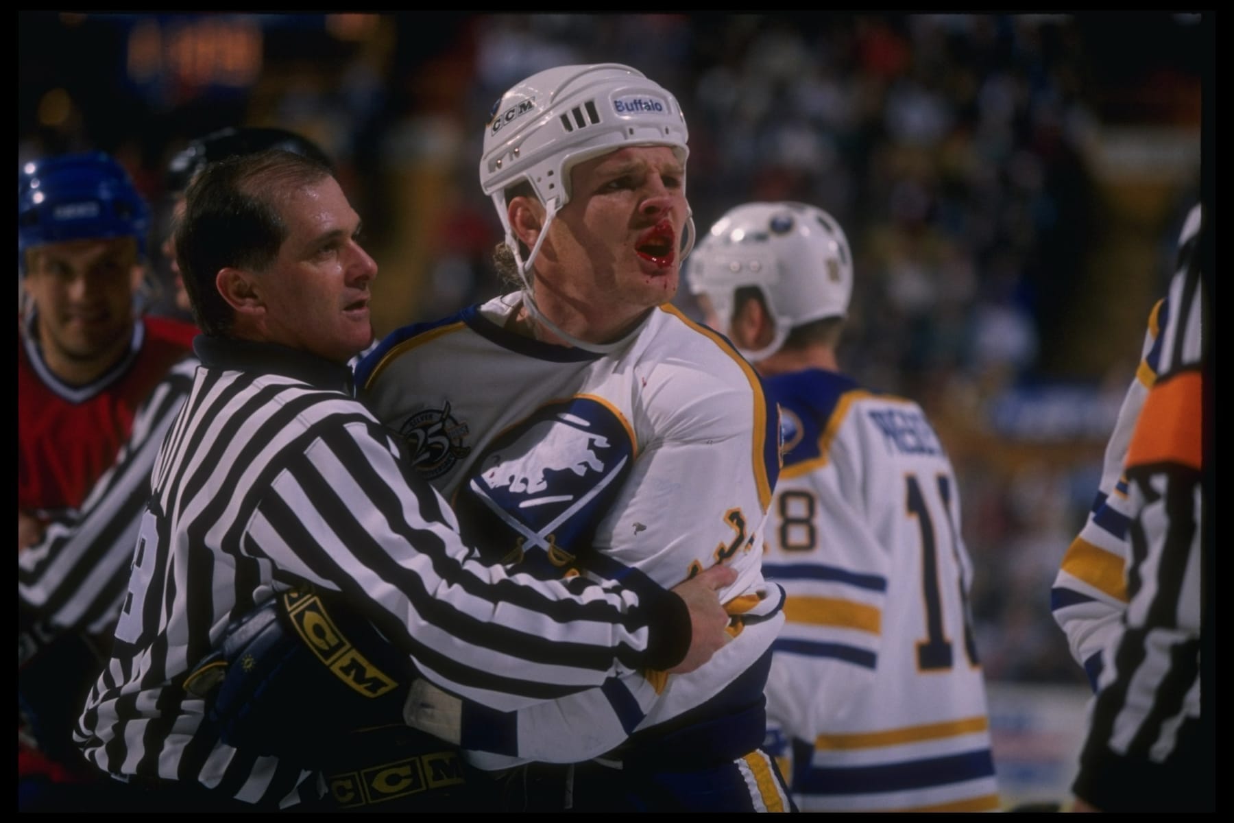 6 Mar 1995: Leftwinger Rob Ray of the Buffalo Sabres is held back by an official during a game against the Montreal Canadiens at Memorial Auditorium in Buffalo, New York. The Sabres won the game, 4-1.